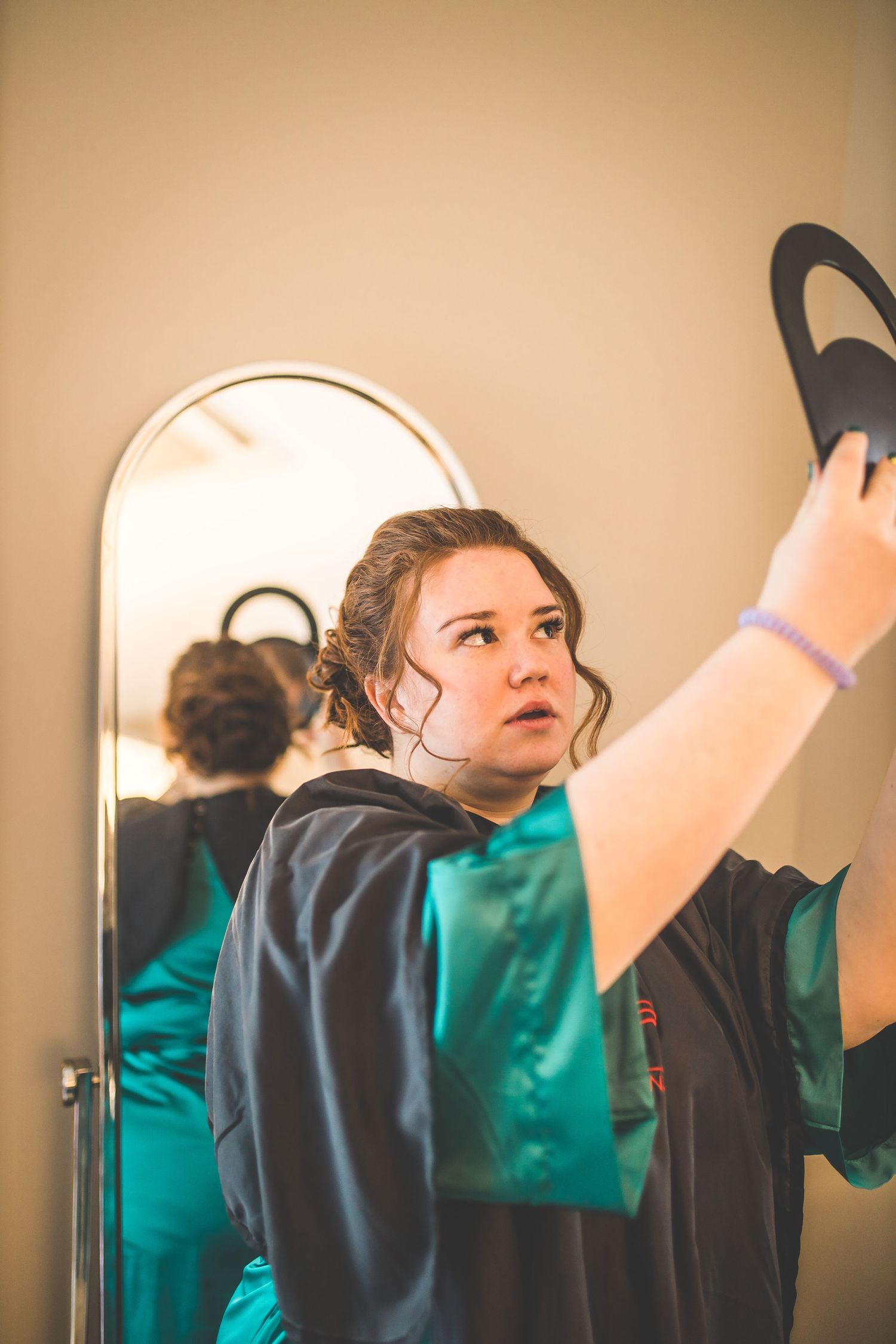 Wedding preparation scene showing someone getting ready in front of a mirror.