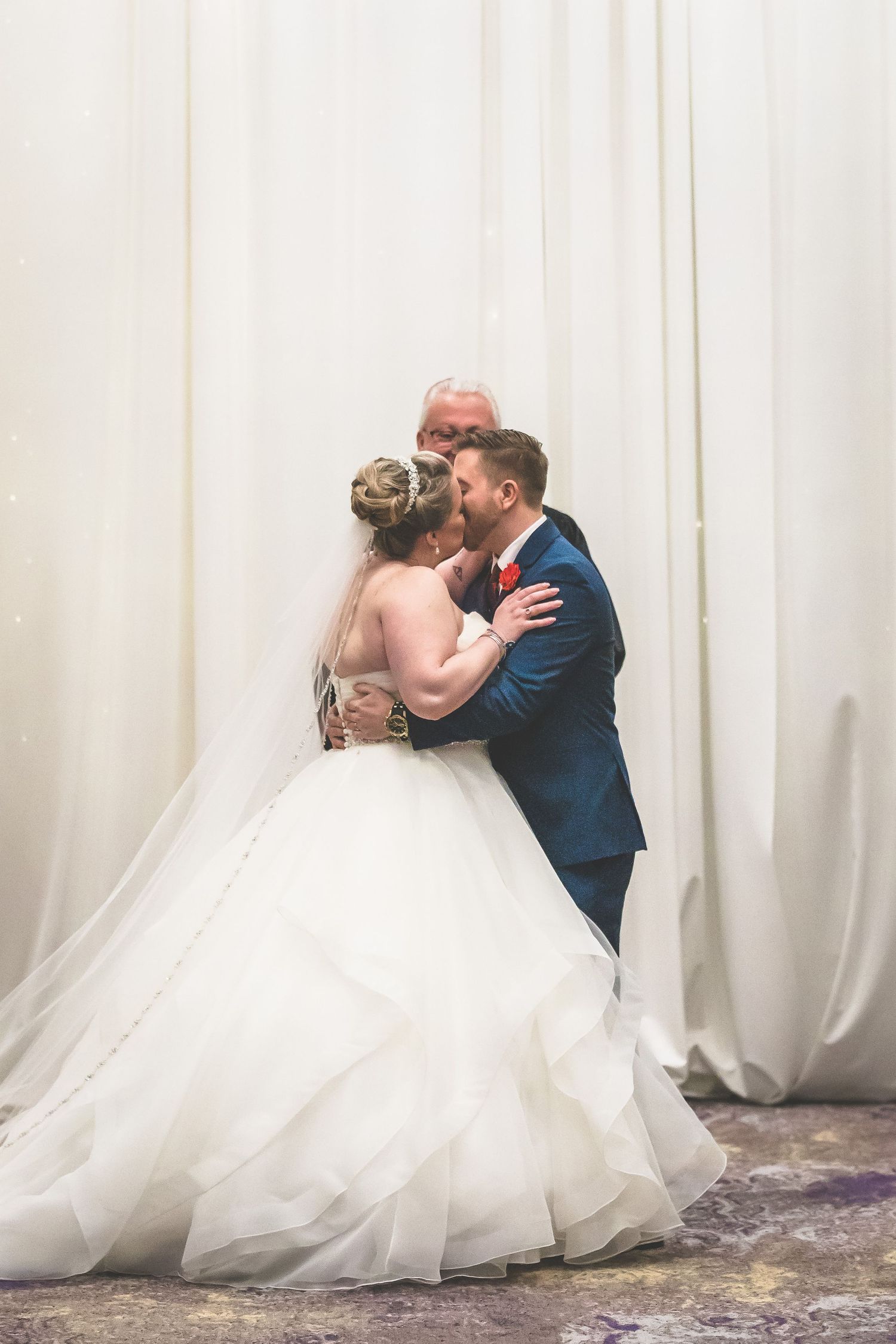 Romantic wedding couple shares intimate kisses in a series of elegant portraits against a white backdrop.