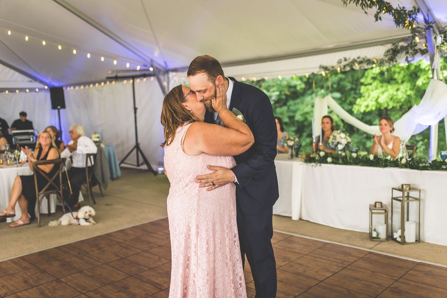 Wedding reception dance floor moments captured under a beautifully decorated white tent.