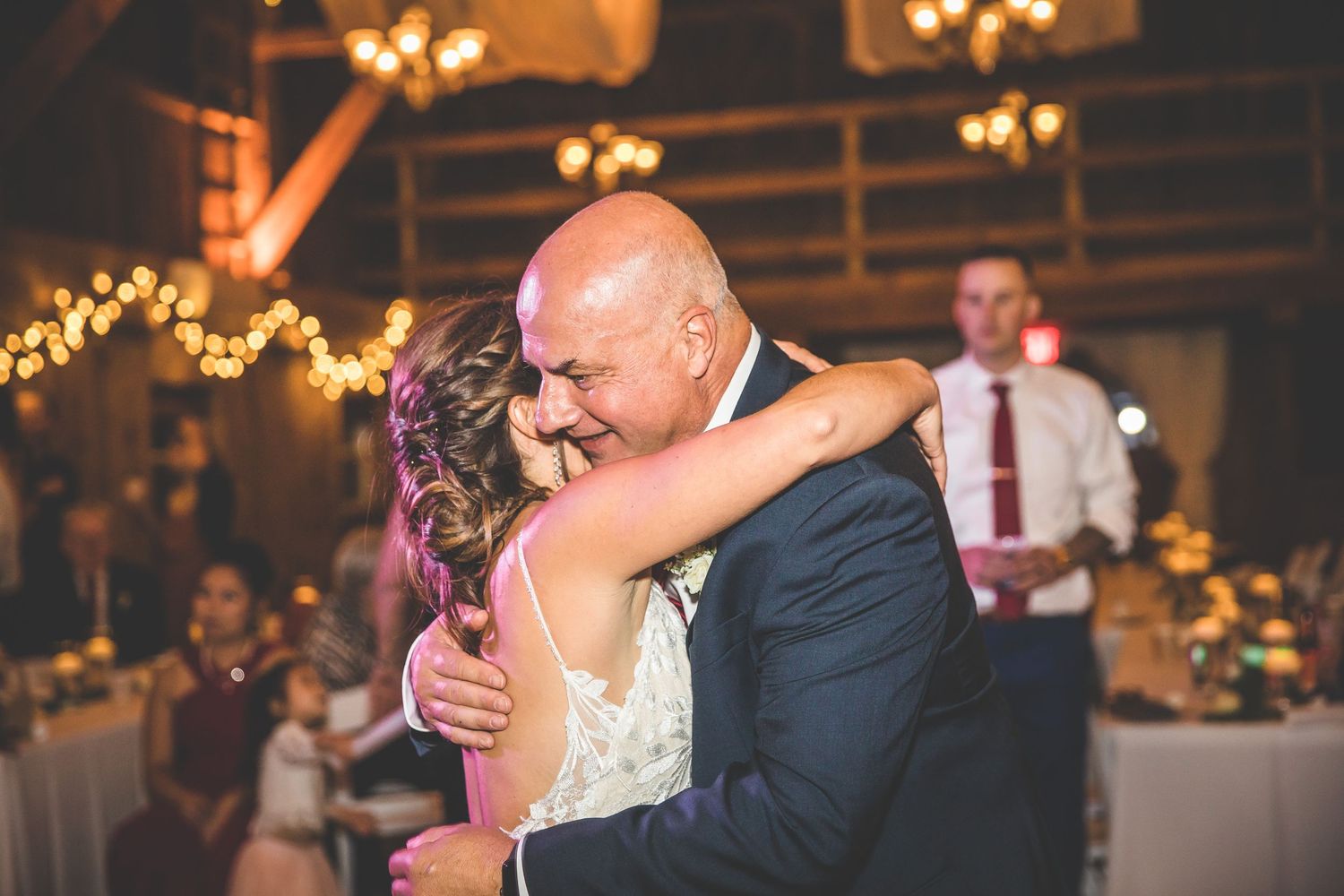 Couples dancing together at an evening wedding reception with ambient lighting.