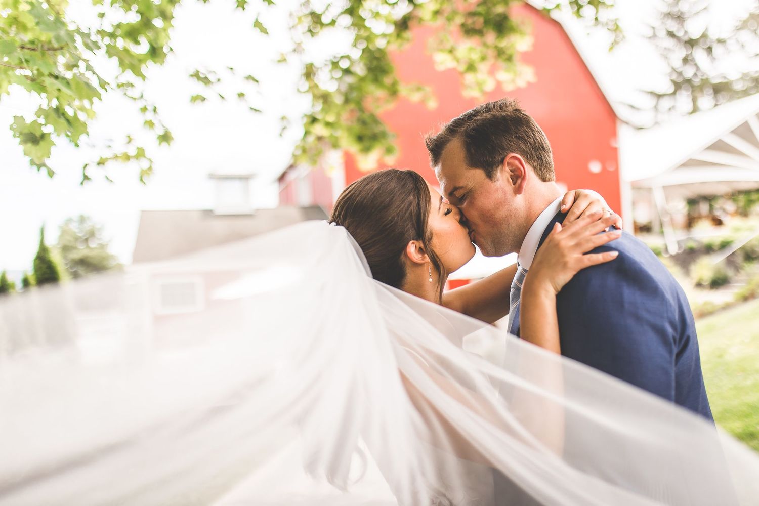 Romantic wedding portraits captured under green trees with soft natural lighting.