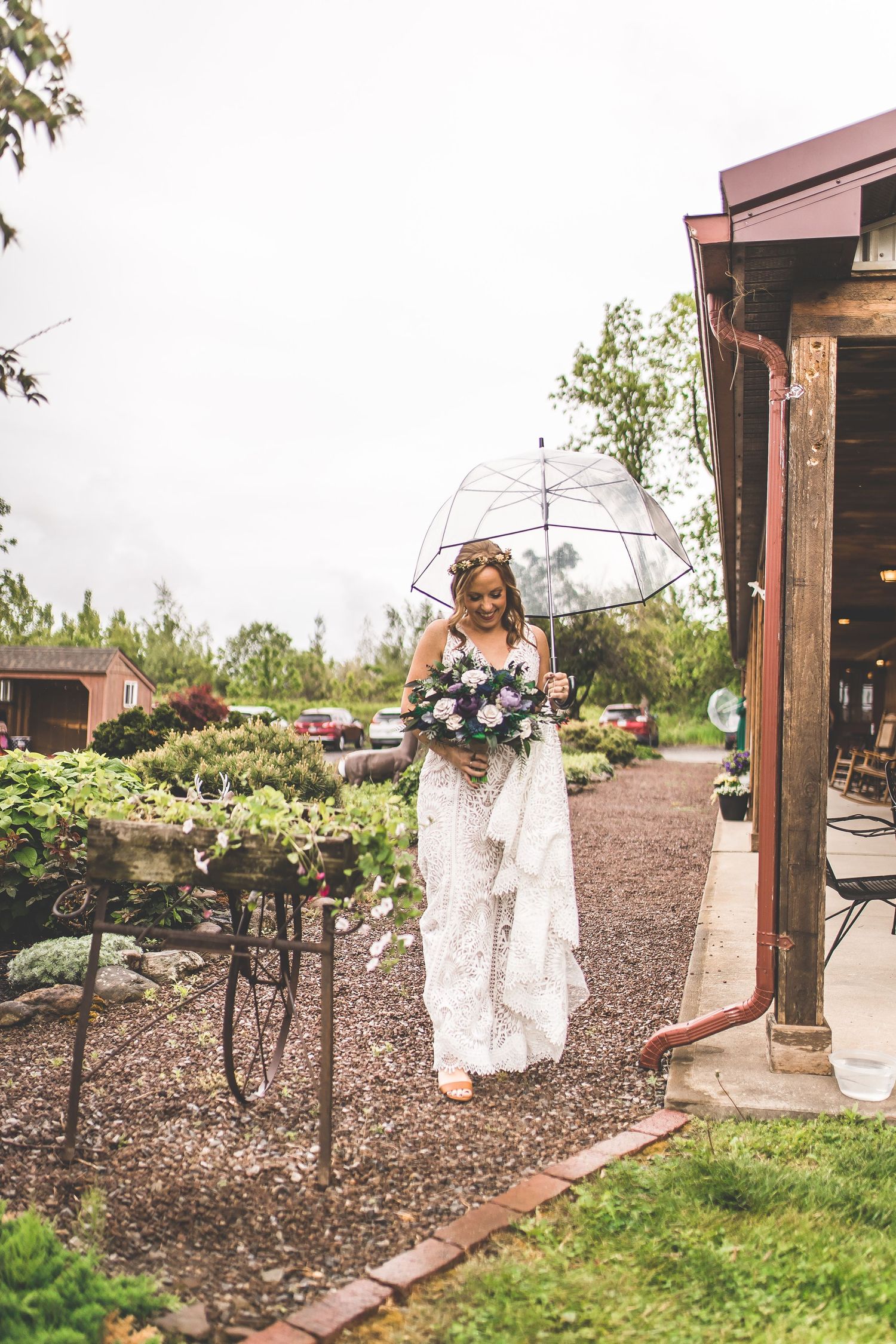 Bride in lace dress twirls on outdoor patio of rustic venue.