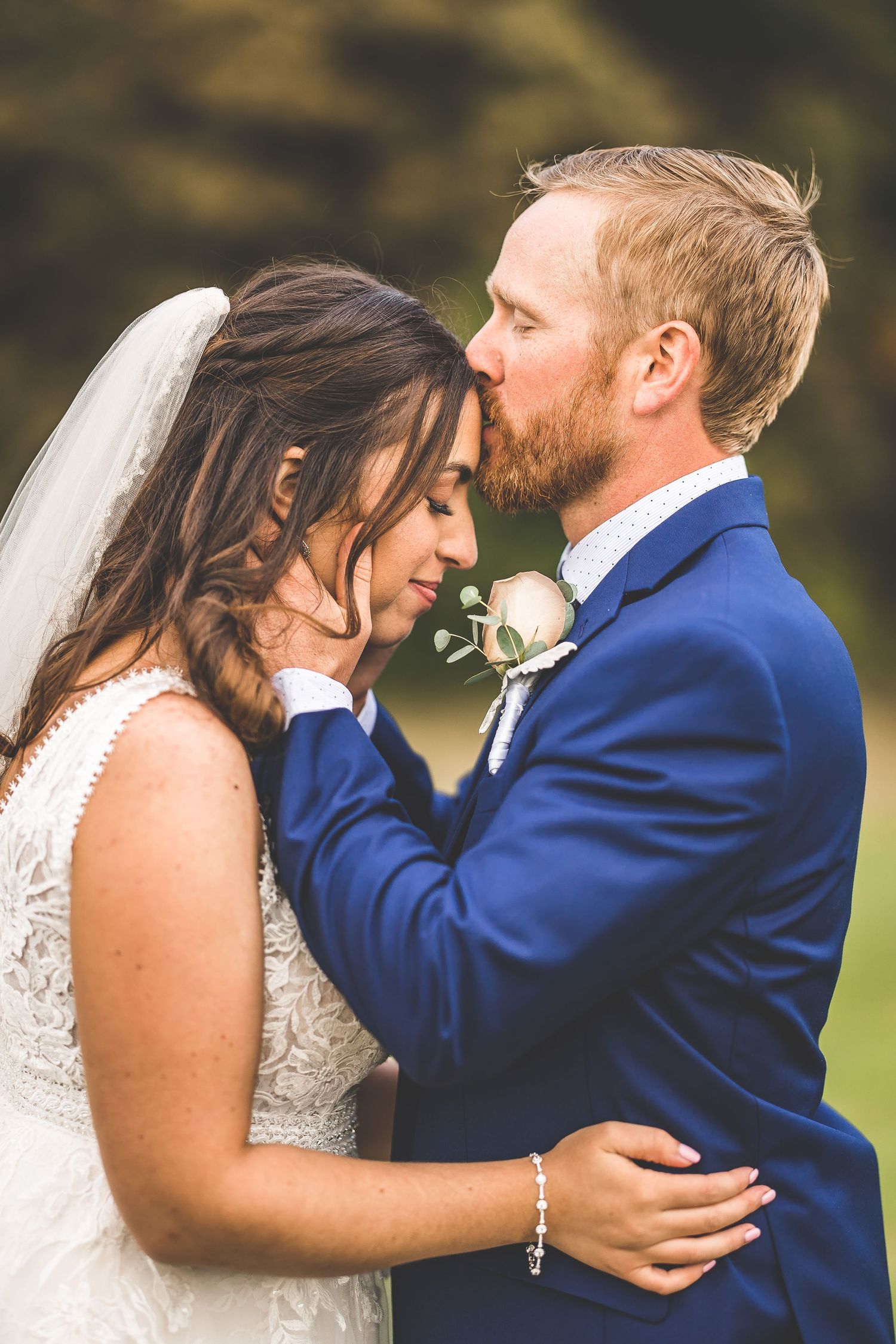 Close-up wedding portraits show tender moments between couple in navy suit and white dress.