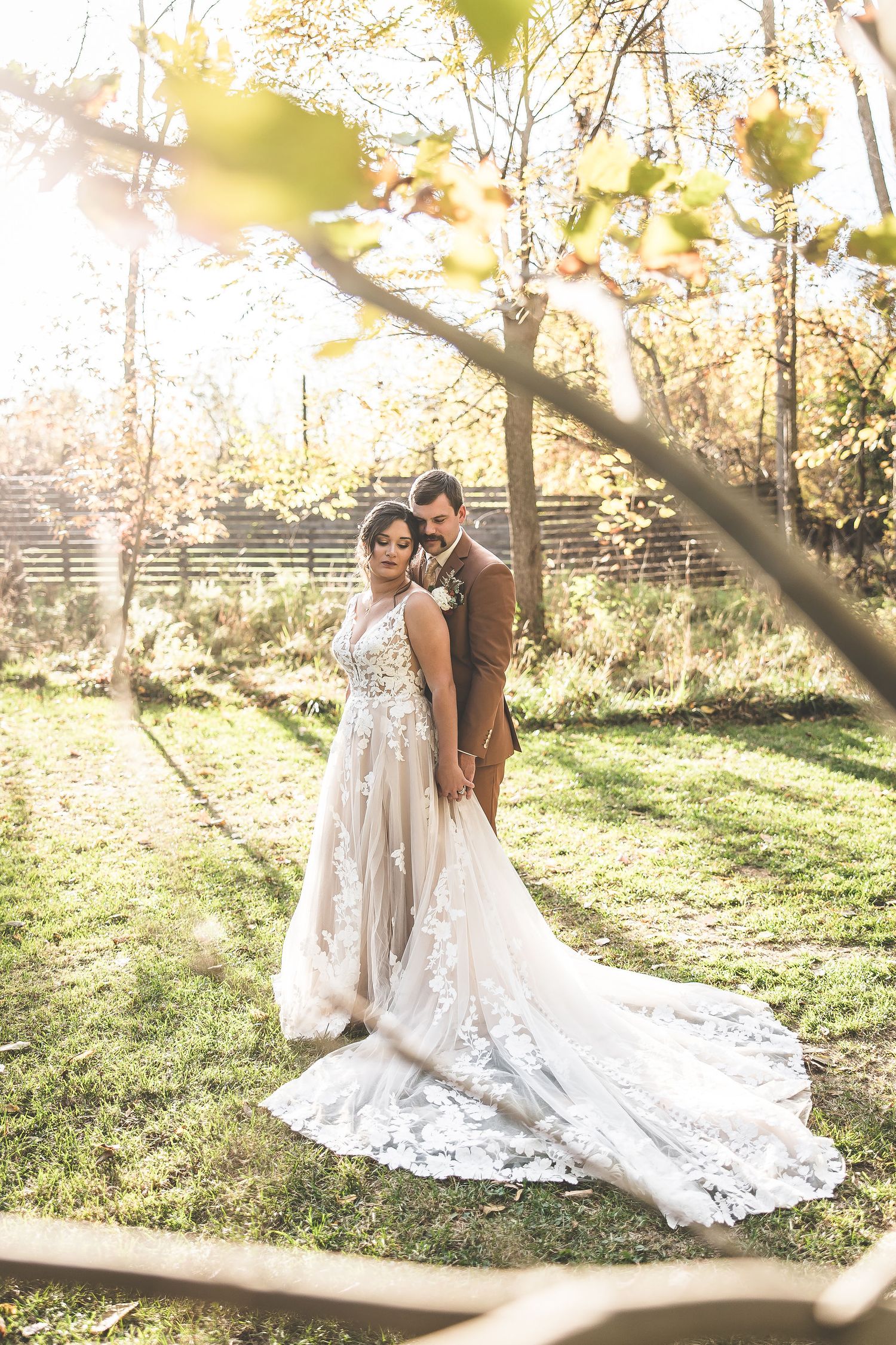 Elegant wedding portraits showcase a beautiful lace train dress against natural autumn scenery.