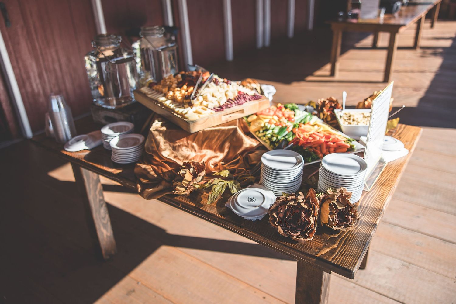 Rustic wedding reception buffet table with various dishes and decorative displays.