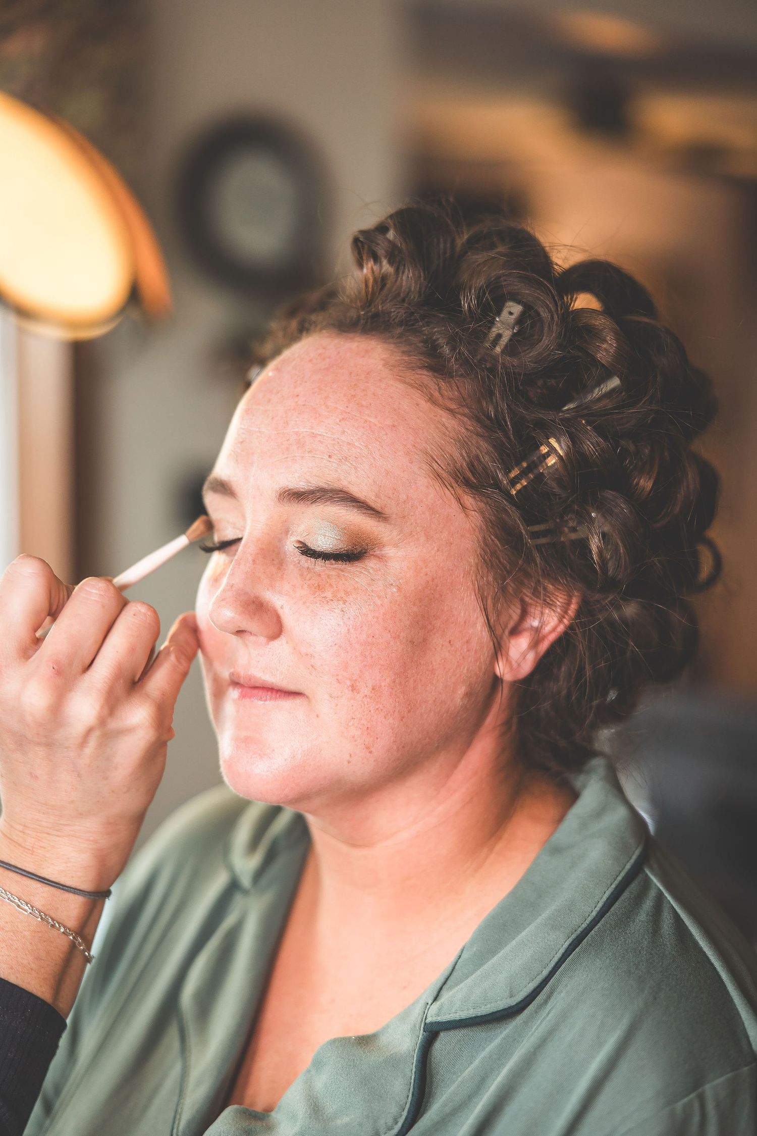 Close-up shots of makeup application during wedding preparations.