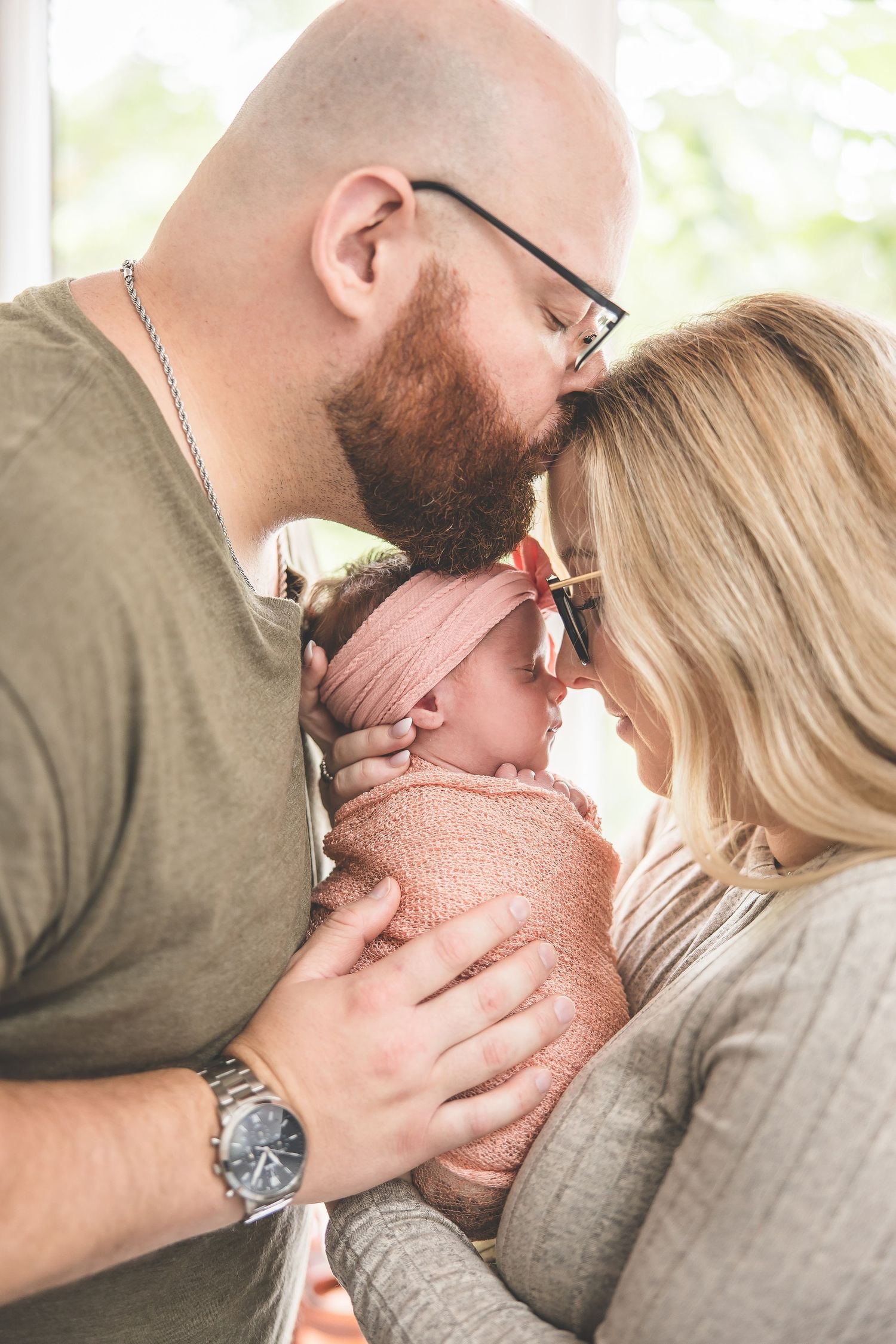 Tender family moments captured with a newborn baby in soft natural lighting.