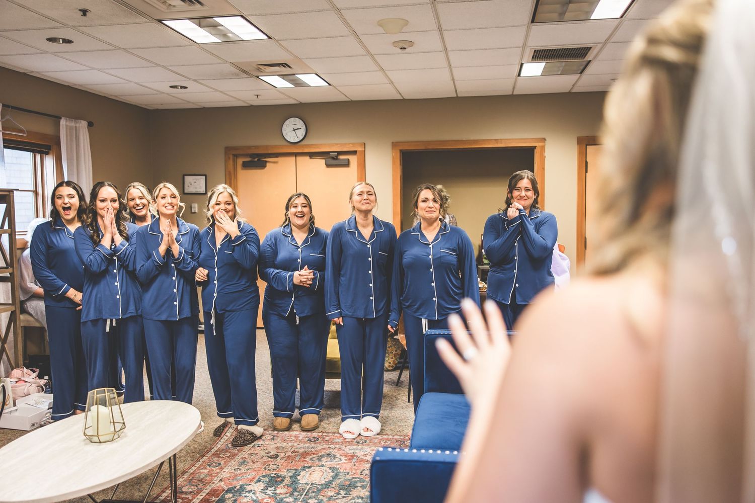 A group in coordinated navy blue attire reacting with excitement in an indoor setting.
