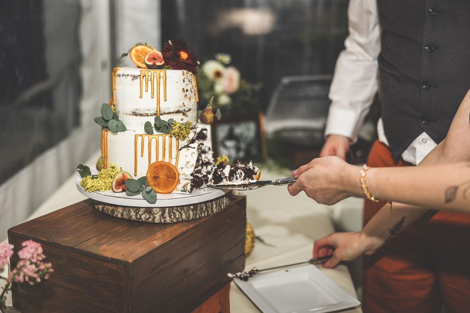 Elegant white wedding cake with gold accents and floral decorations on display.
