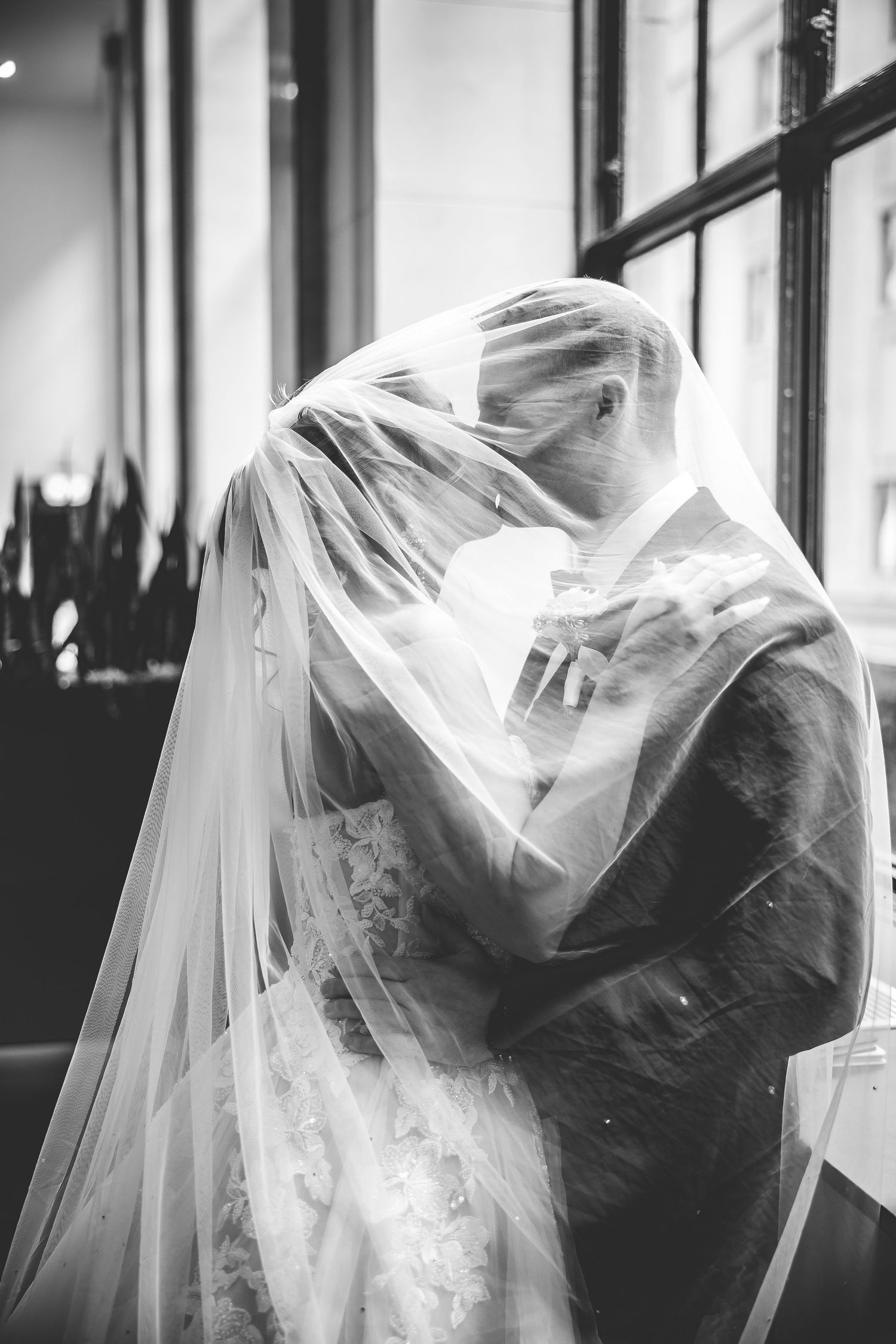 Artistic black and white photo of a flowing wedding veil creating dramatic shadows.