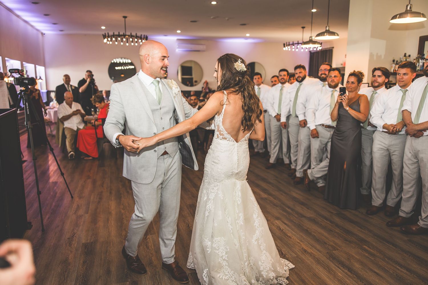 Wedding reception dance floor with purple ambient lighting and hardwood flooring.
