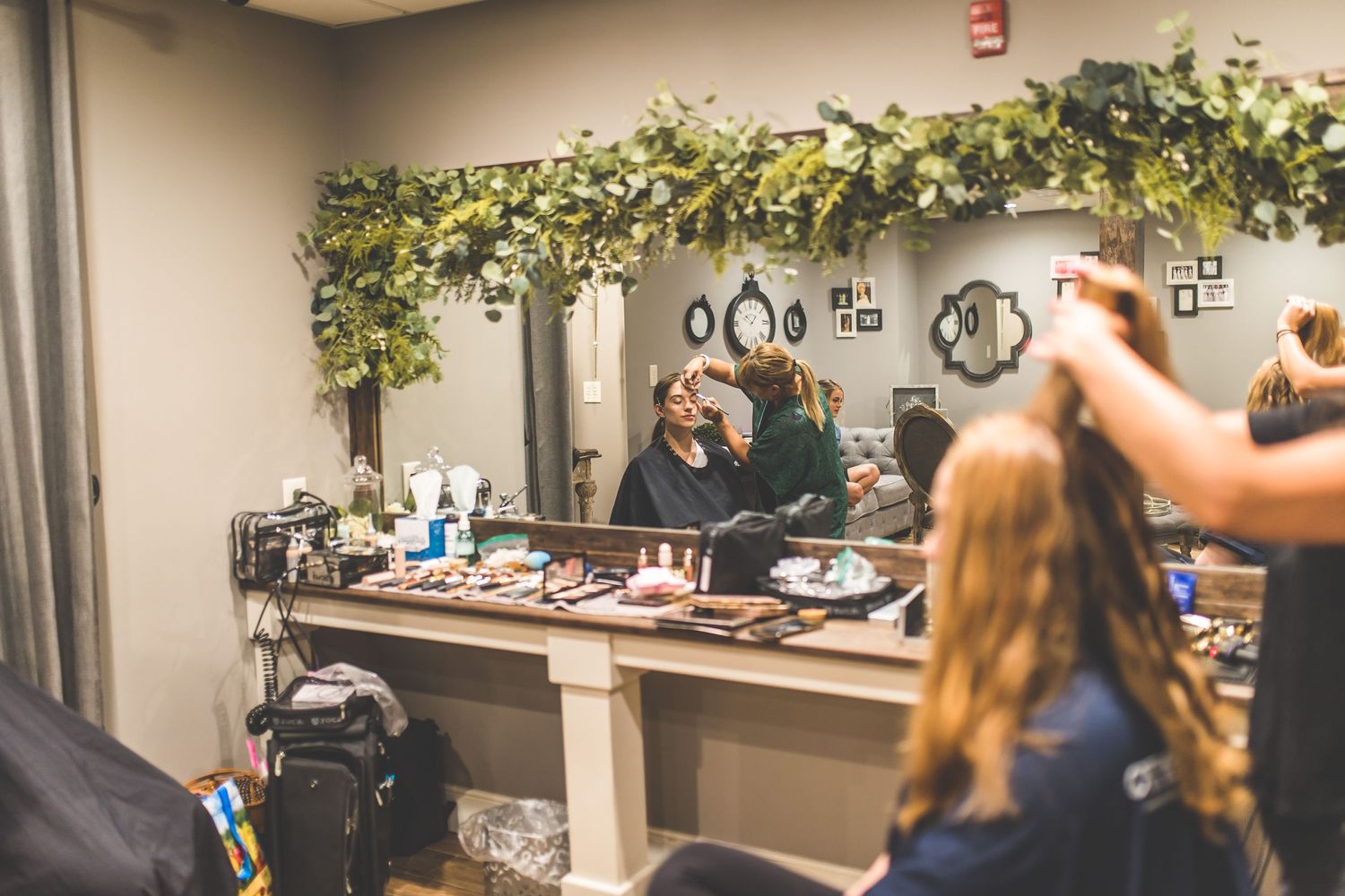 Wedding preparation room decorated with greenery and modern decor elements.