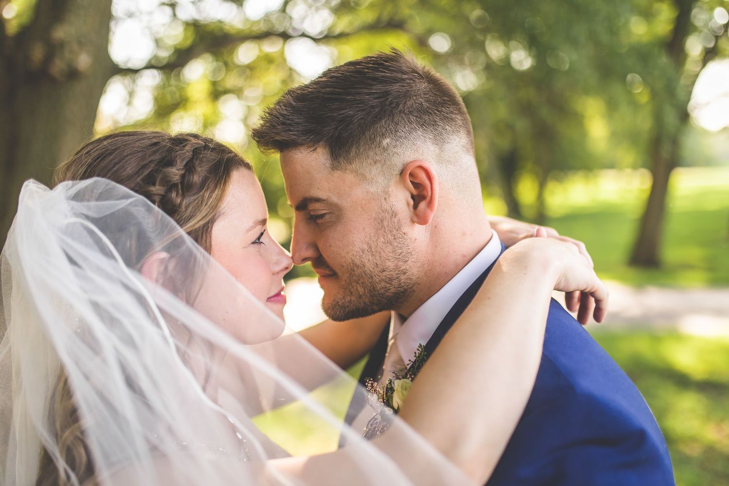 Intimate wedding couple portraits taken under trees in golden afternoon light.