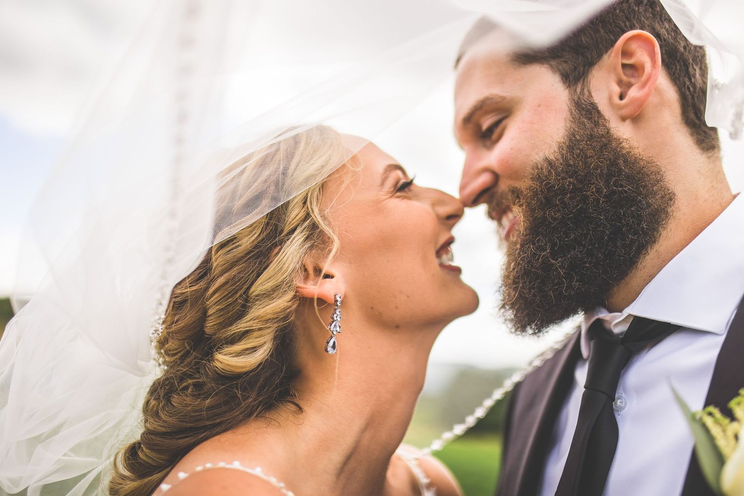 Romantic close-up wedding photos showing tender moments between newlyweds in an outdoor setting.