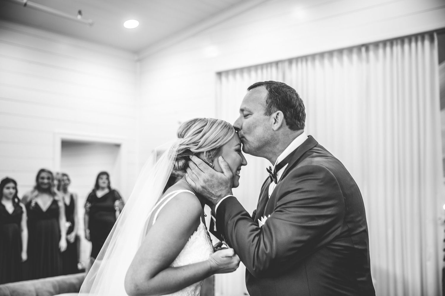 Black and white photo of an emotional first dance at a wedding reception.