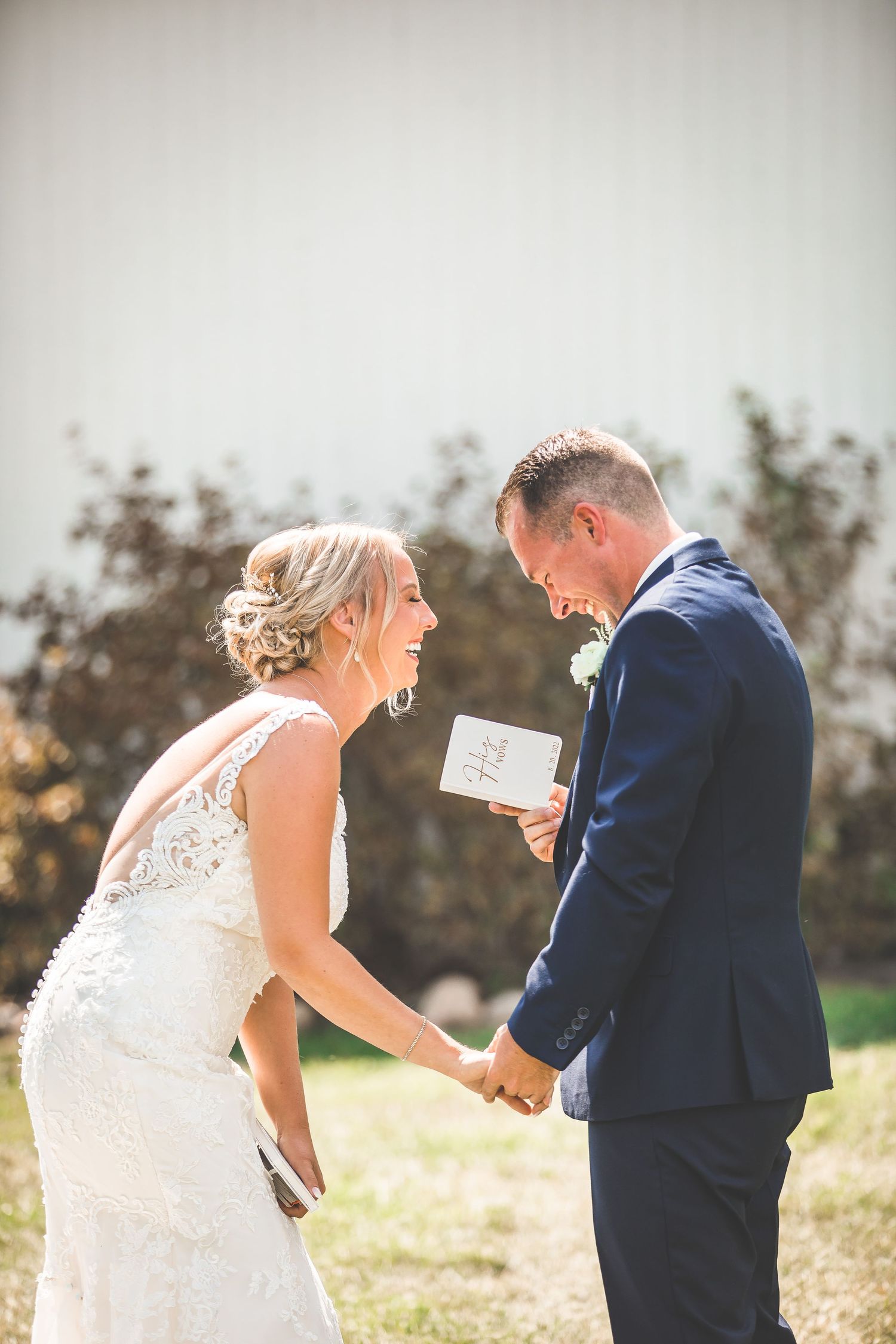 An emotional reaction during a first look as the couple reads personal vows outdoors.