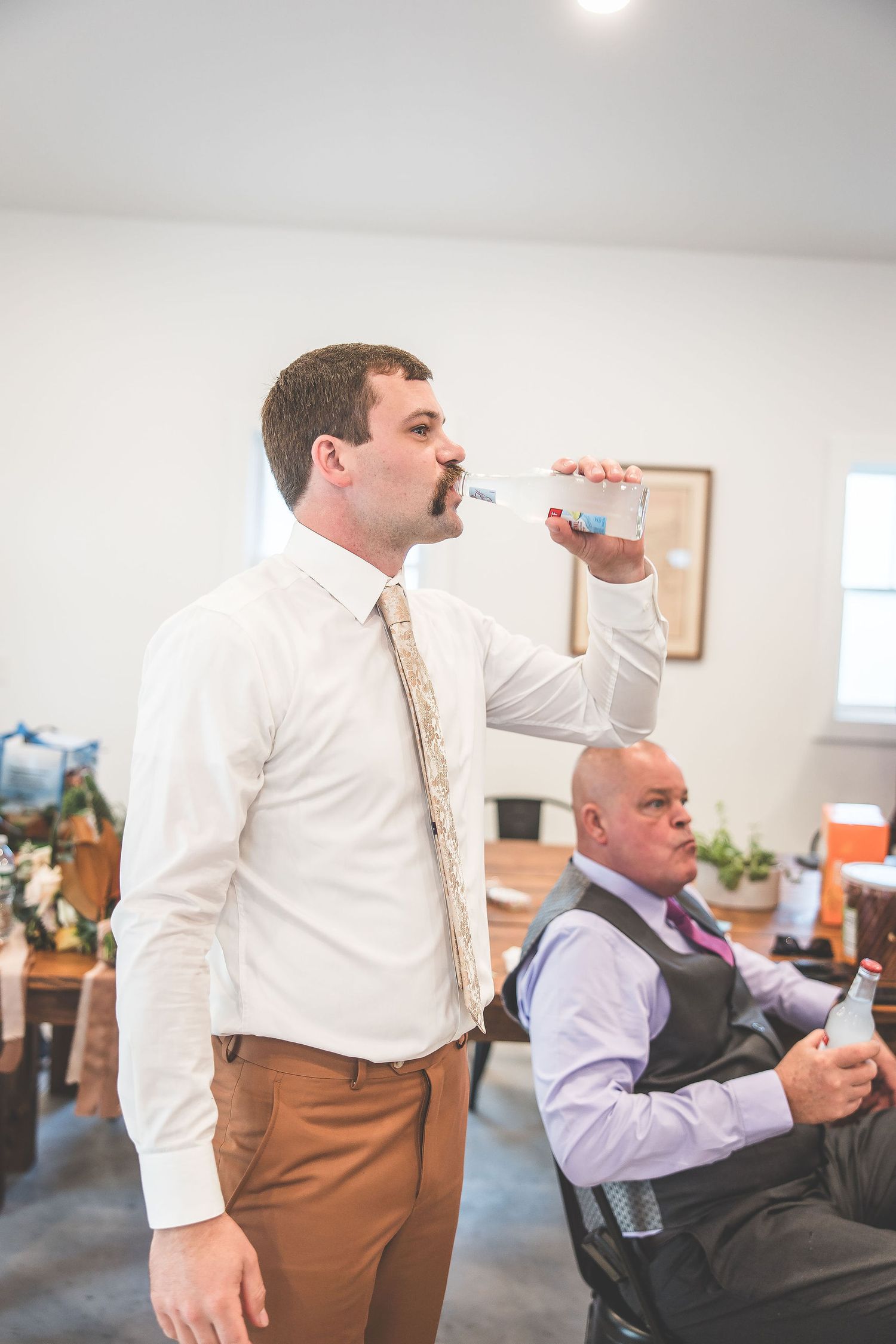 Wedding preparation scene indoors with formal attire and casual moments.