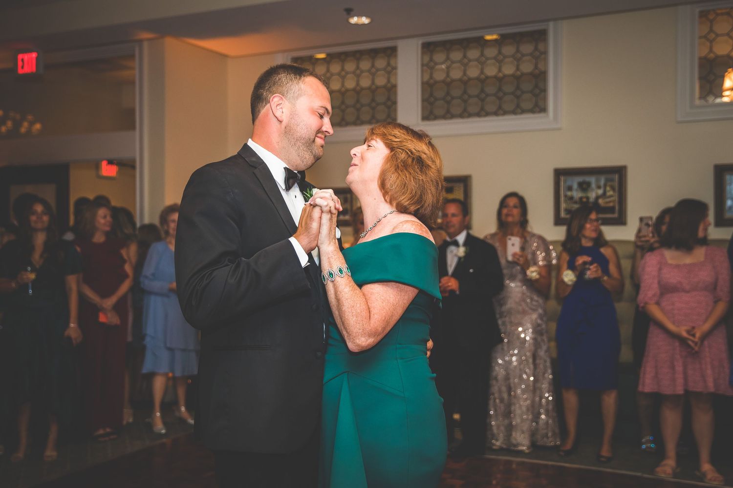Couple sharing a romantic dance moment at an elegant indoor wedding reception.