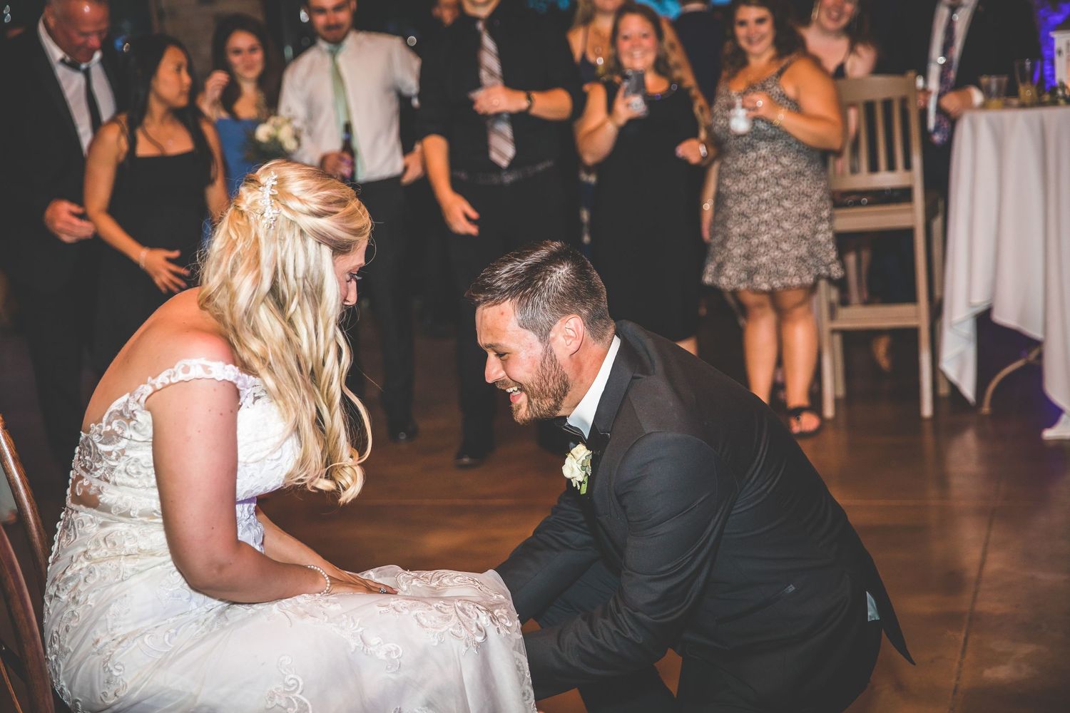 Couple shares a playful moment during their wedding reception on the dance floor.