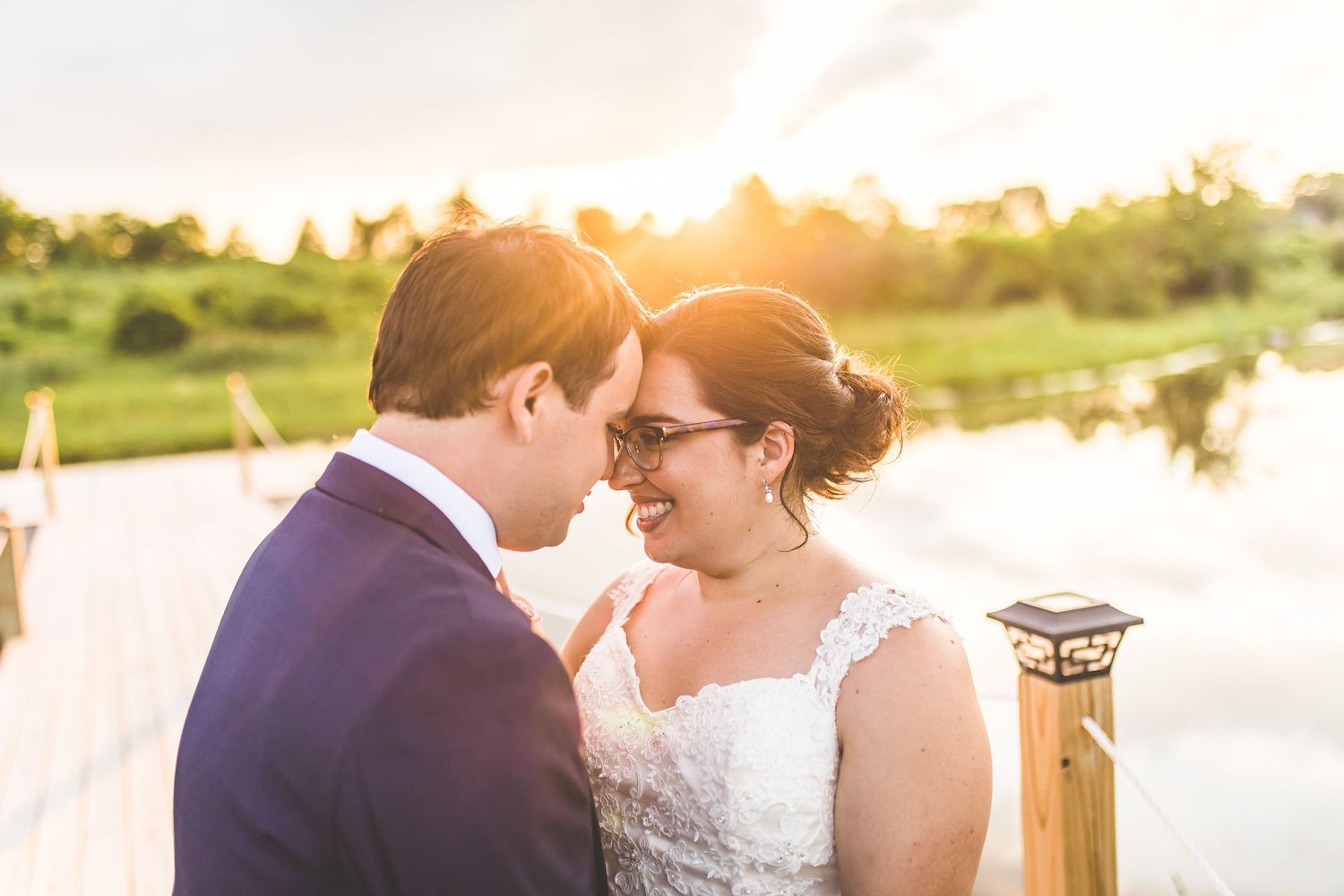 Intimate wedding portraits taken during golden hour on a waterfront dock.