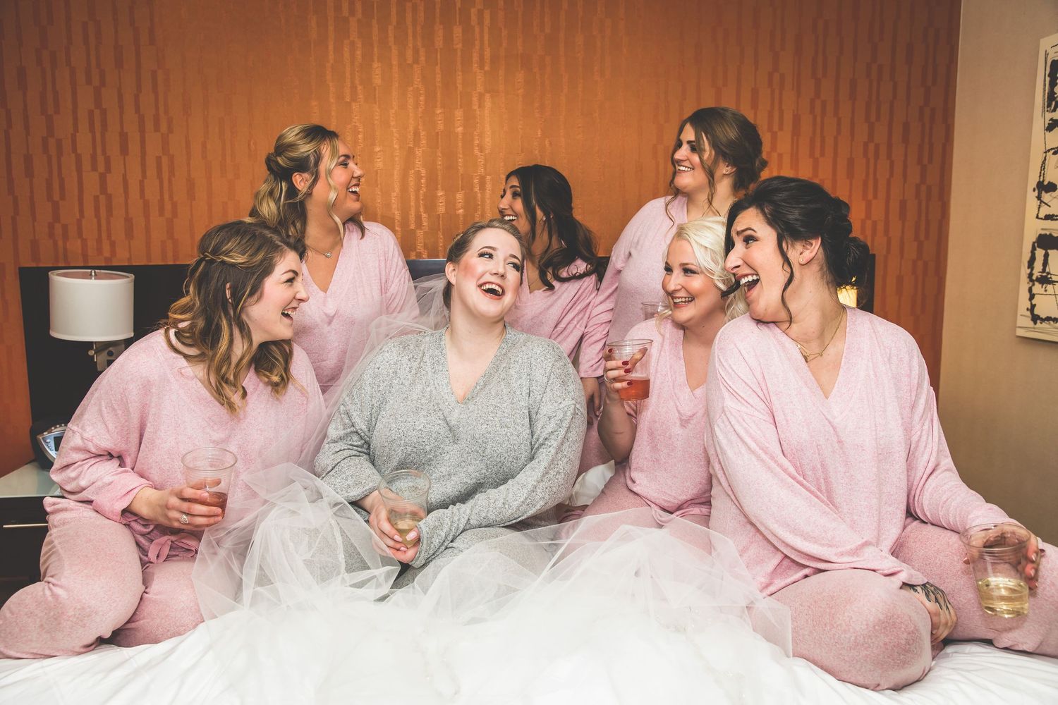 Group wearing matching pink and gray robes sitting together.