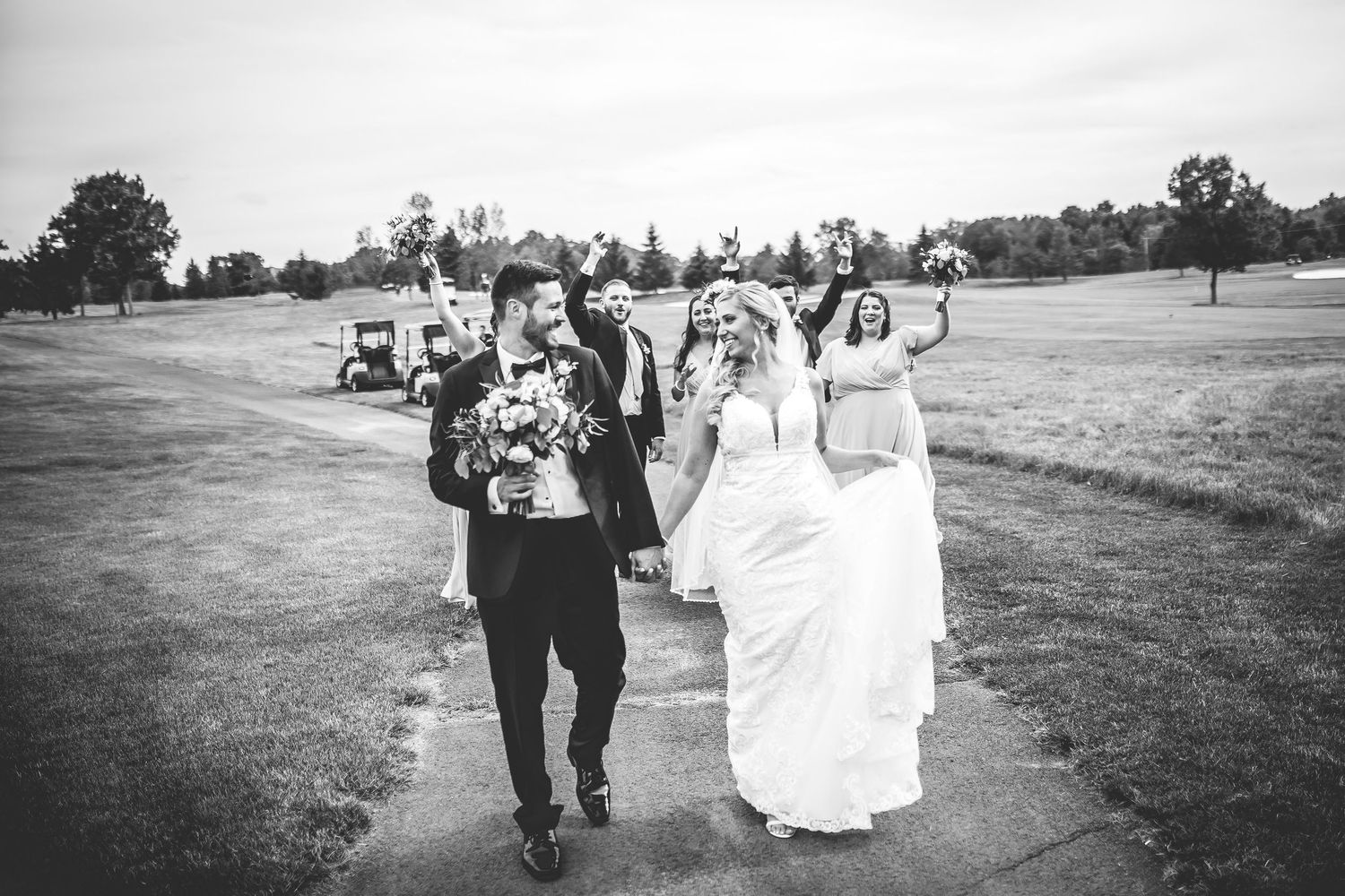 Black and white photos of wedding party walking across an open field.