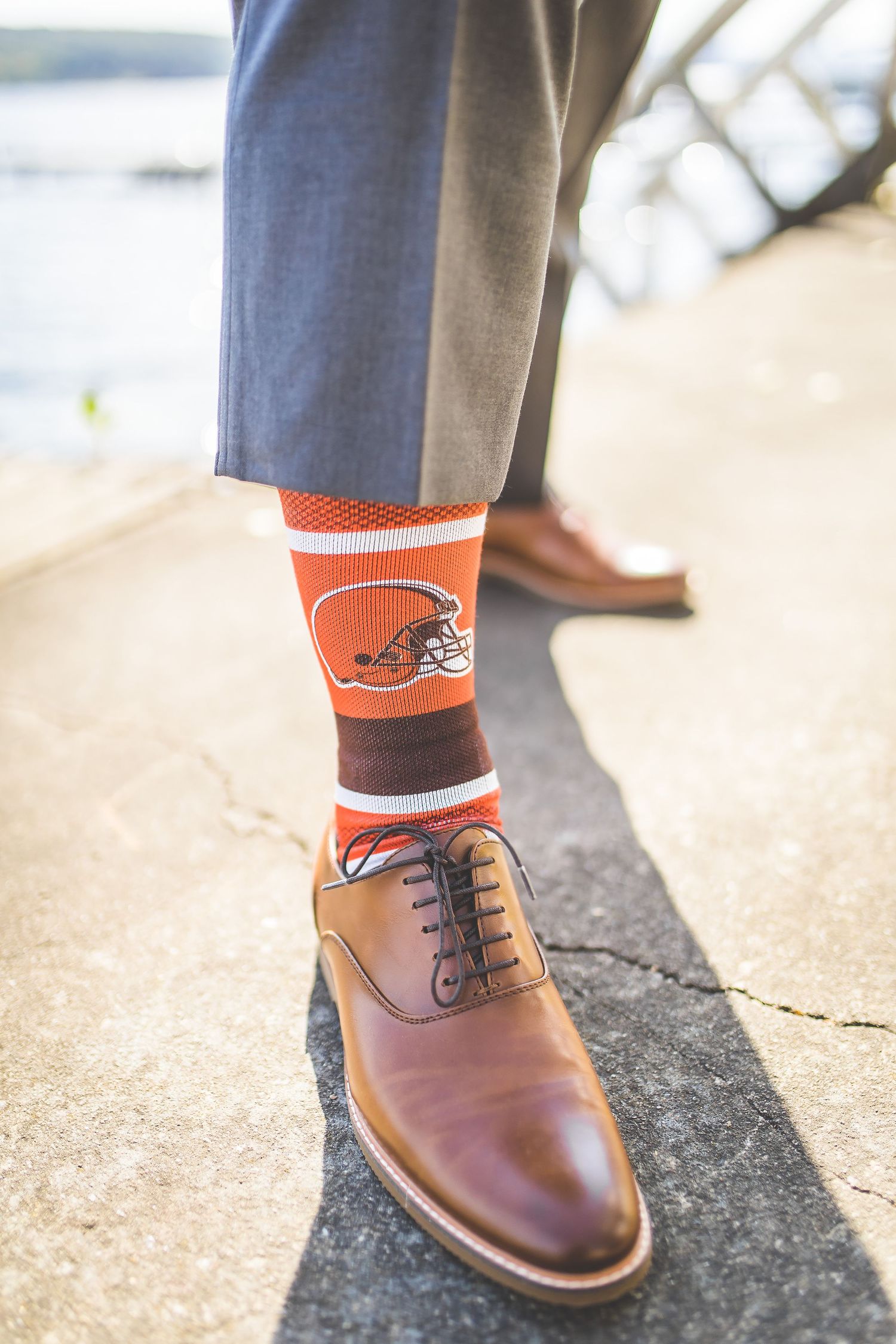 Brown leather dress shoes paired with orange sports team socks.