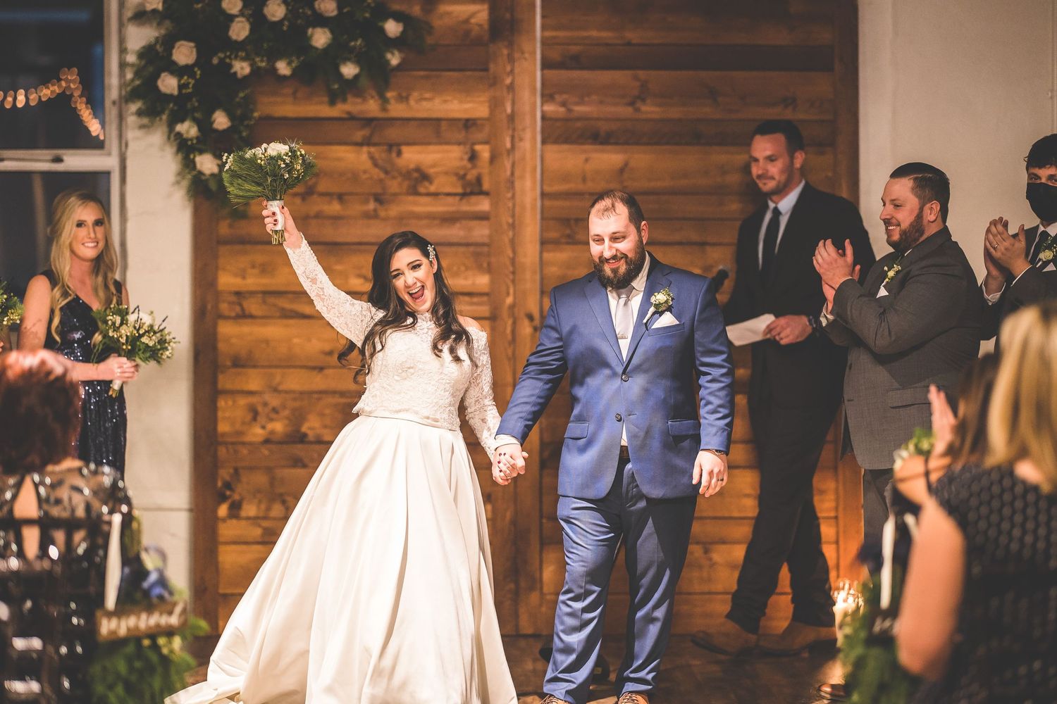 Wedding celebration in a modern venue with rustic wooden walls and floral decorations.