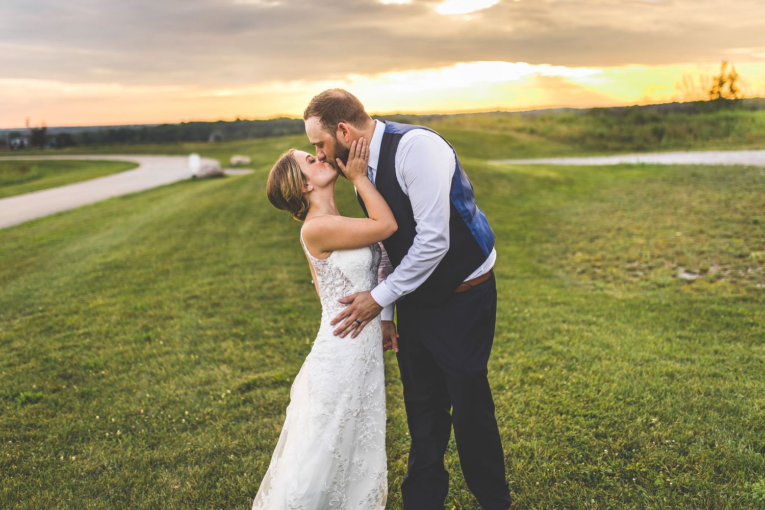 Couple shares a romantic dance in an open field at golden hour.