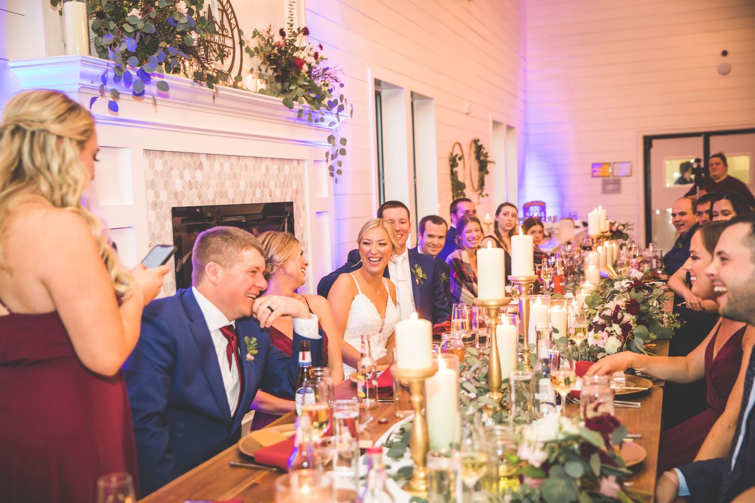 Wedding reception dinner table with candlelight and decorative floral arrangements.