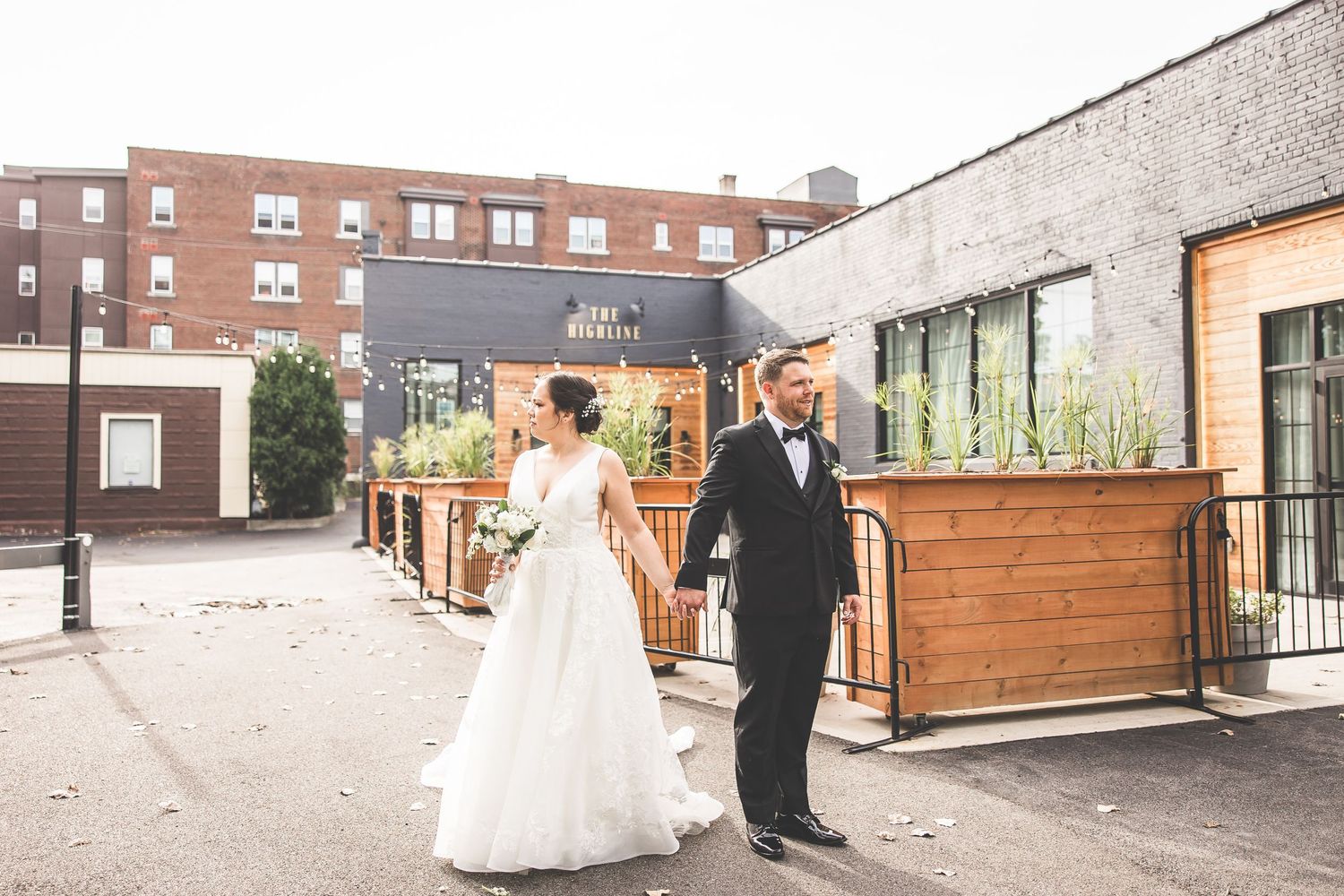 Modern industrial wedding venue featuring brick walls and wooden fencing under evening light.