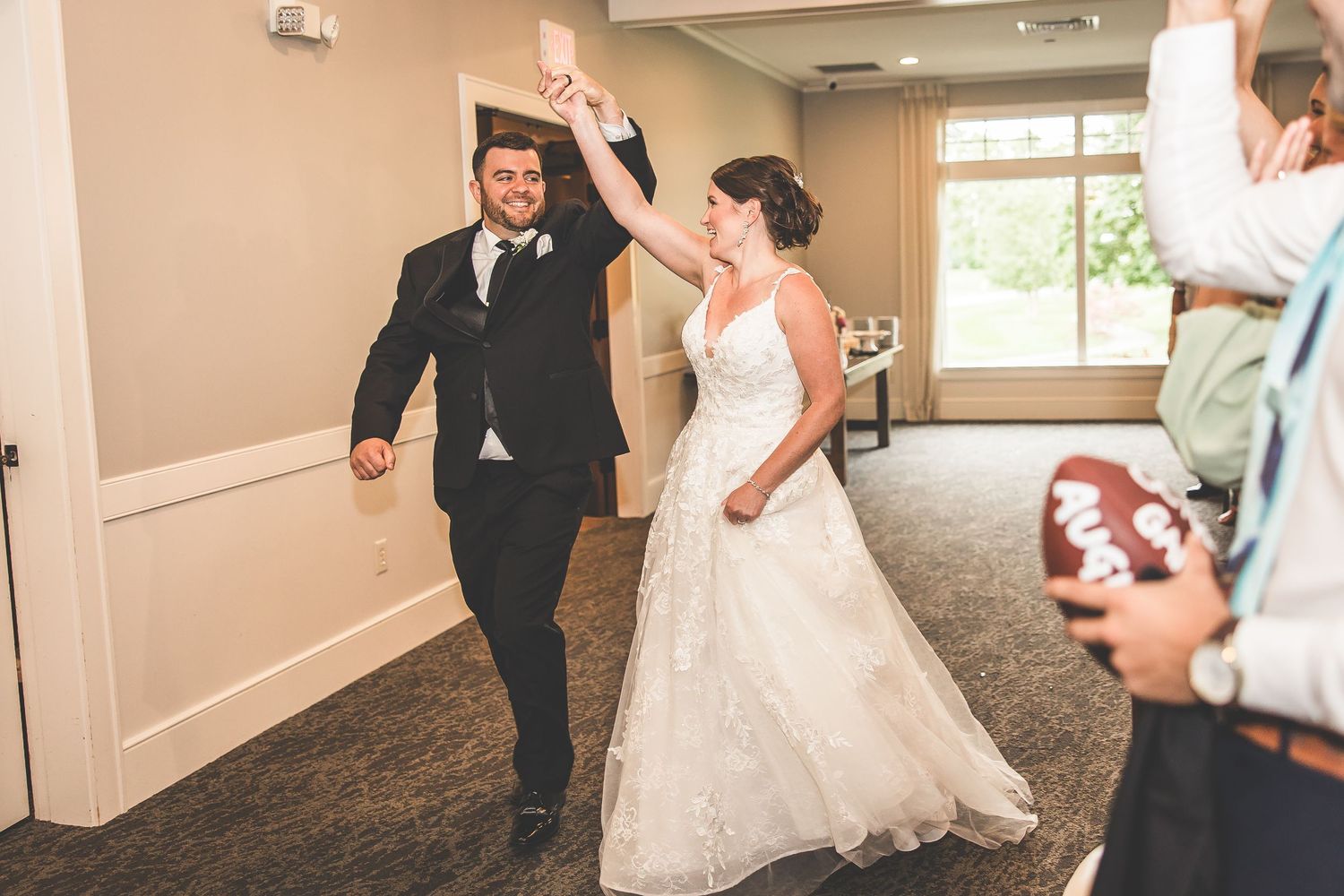 Wedding party dancing and celebrating in an elegant indoor venue with hardwood floors.