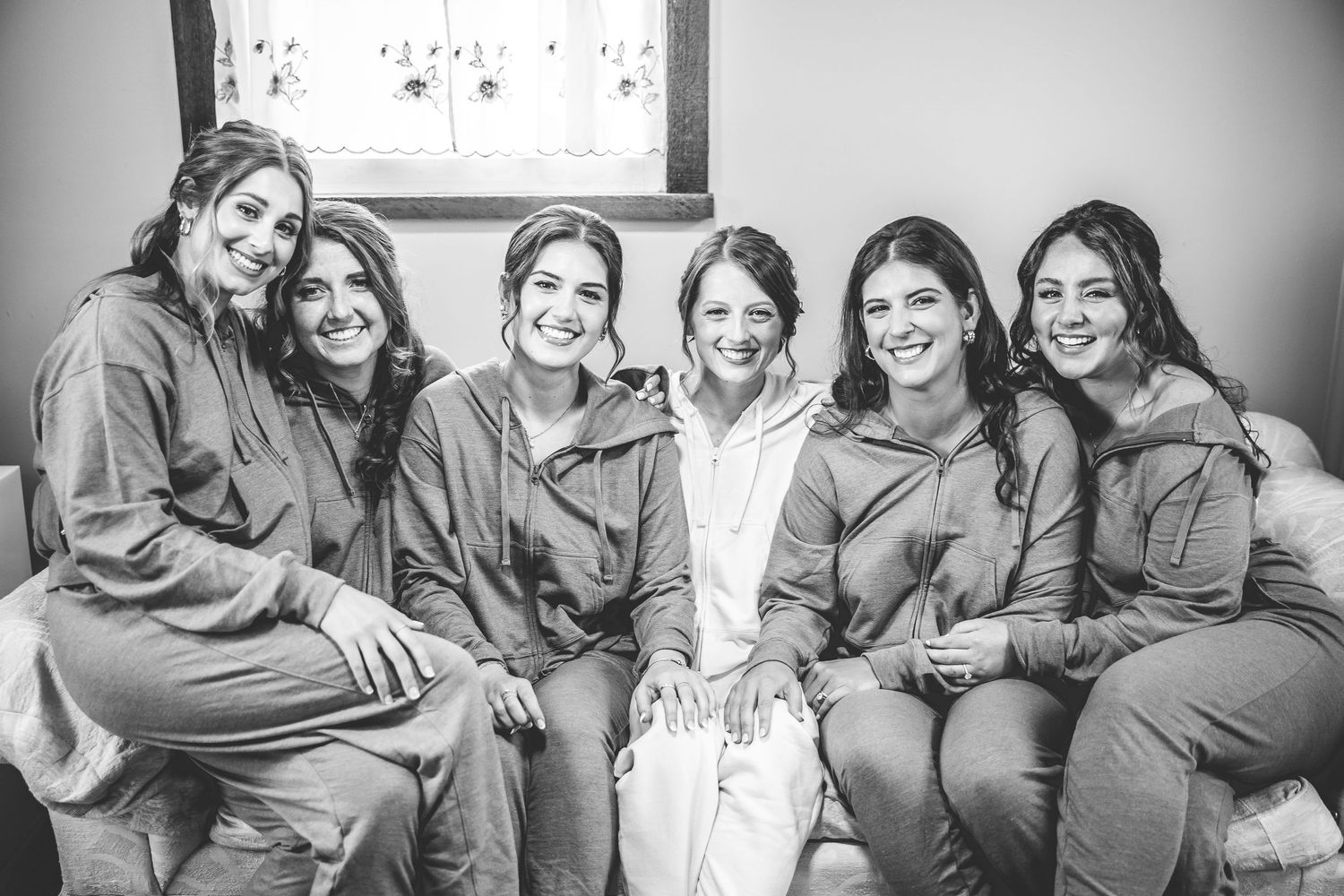 A group wearing matching outfits share joyful moments during a casual photoshoot.