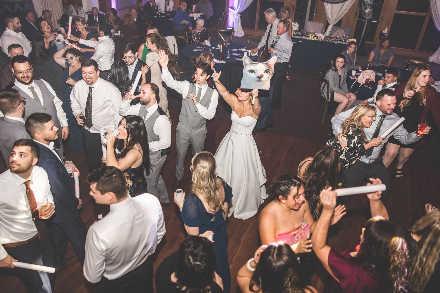 Crowded dance floor with party guests dancing and celebrating at an evening reception.