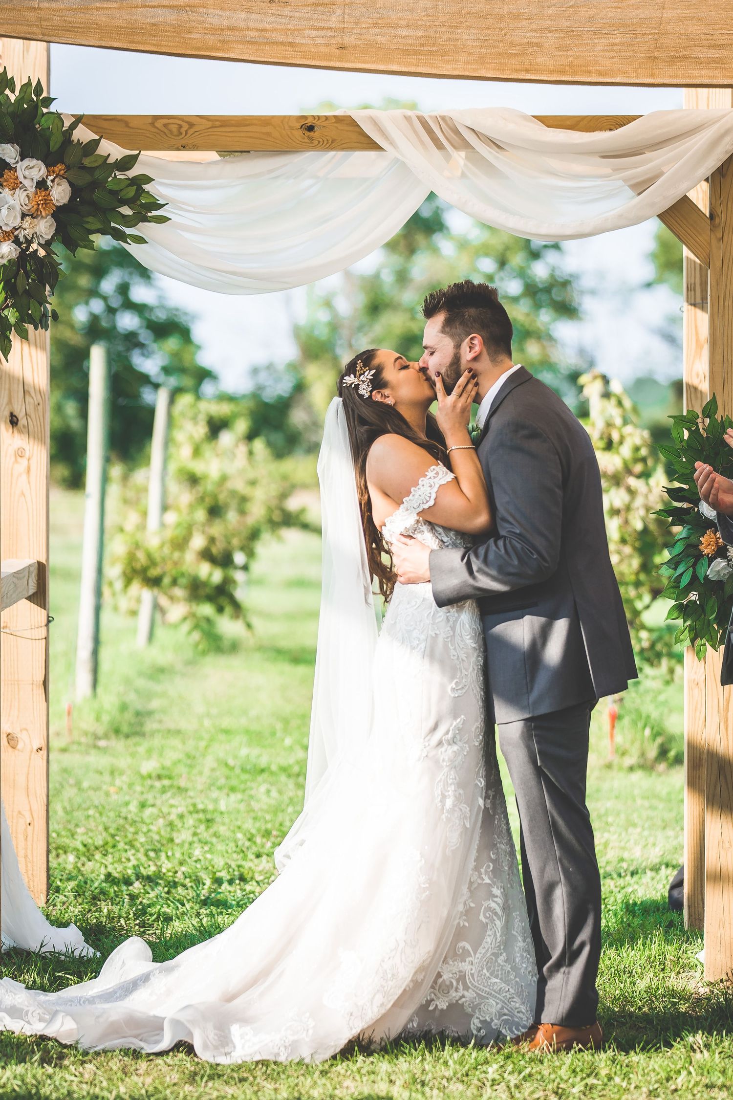 Black and white photo of newlyweds celebrating with guests under outdoor canopy.