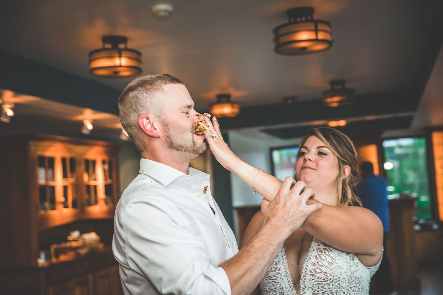 Romantic dance moves captured during wedding reception under warm pendant lighting.