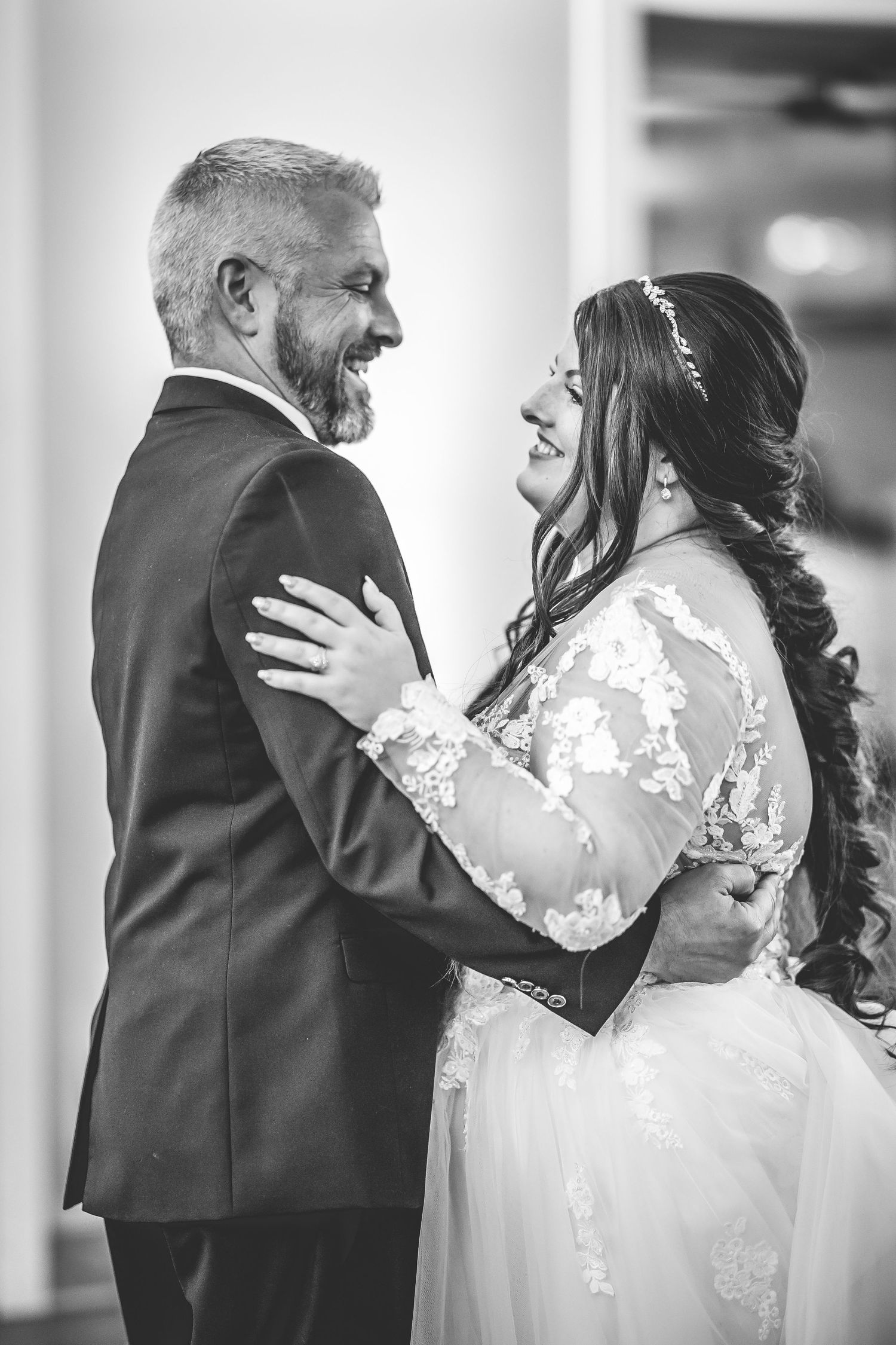 Intimate dance moment captured in black and white with elegant lace wedding dress details.