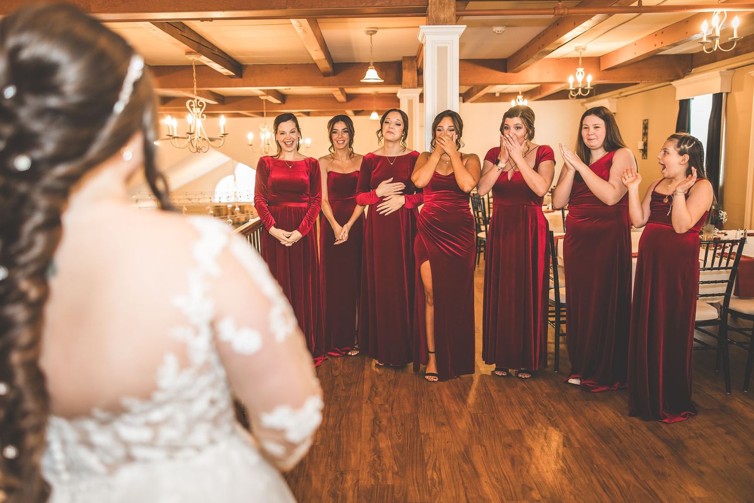 Wedding reception venue with exposed wooden beams and burgundy decor details.