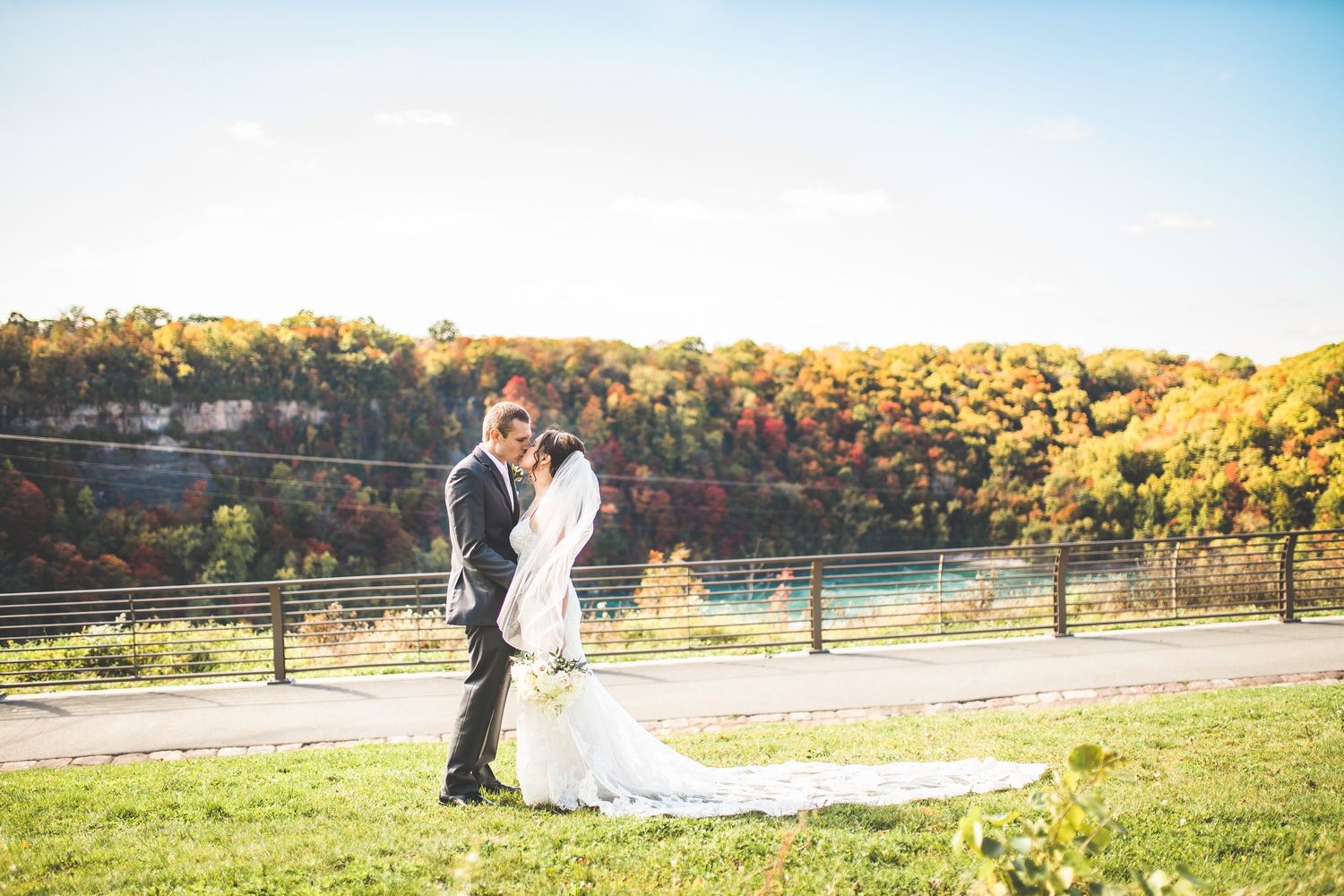 Wedding couple poses in scenic outdoor landscape during golden hour.