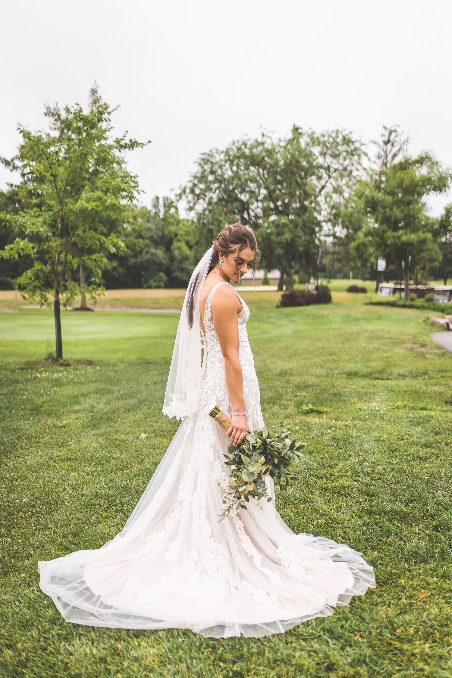 Series of bridal portraits showcasing the flowing train of a white lace wedding dress in an outdoor setting.