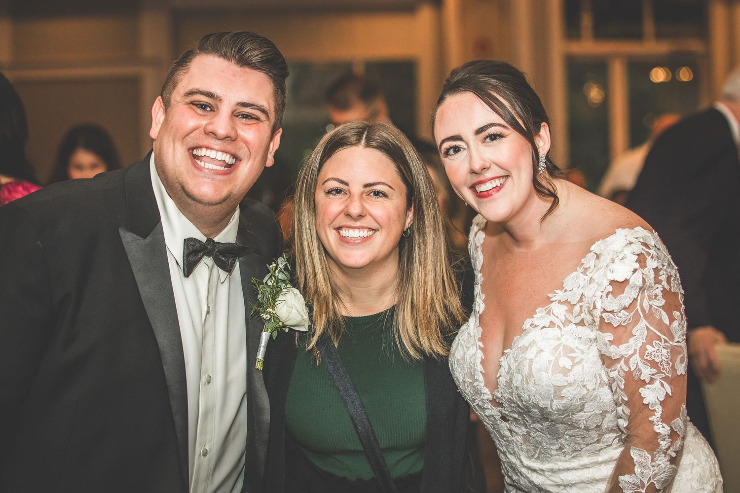 Wedding party members share joyful moments during evening reception celebrations.