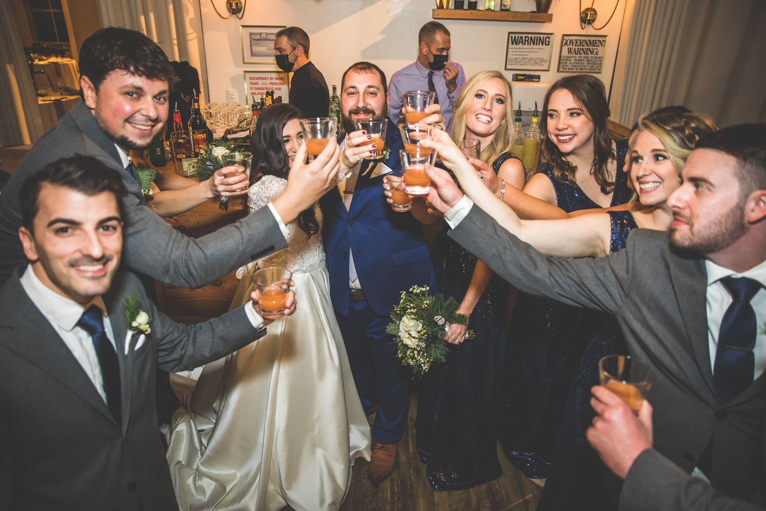 Wedding guests celebrate and dance during a joyful reception in an elegantly lit venue.