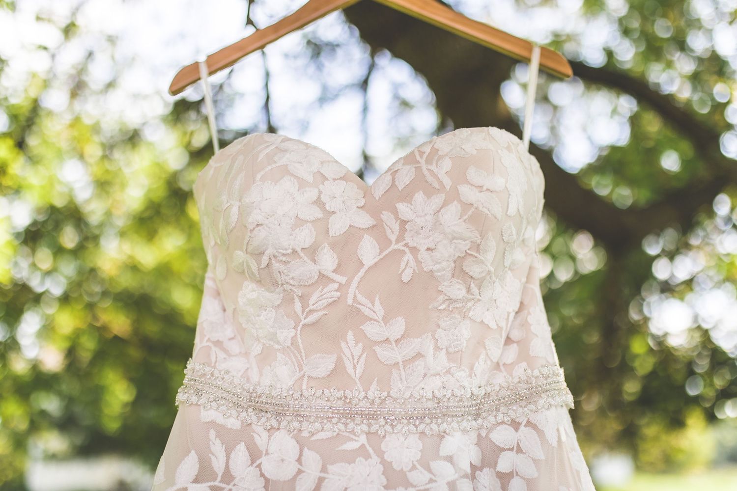 Close-up details of white lace wedding dress bodice.