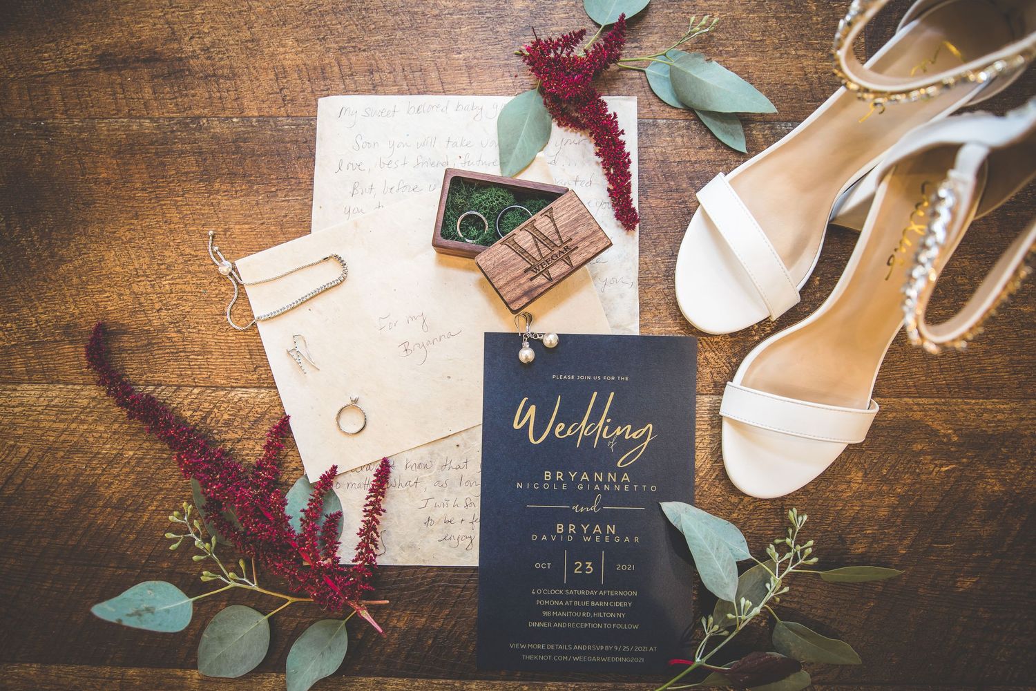 Wedding invitation suite with burgundy florals and navy blue cards on wooden surface.