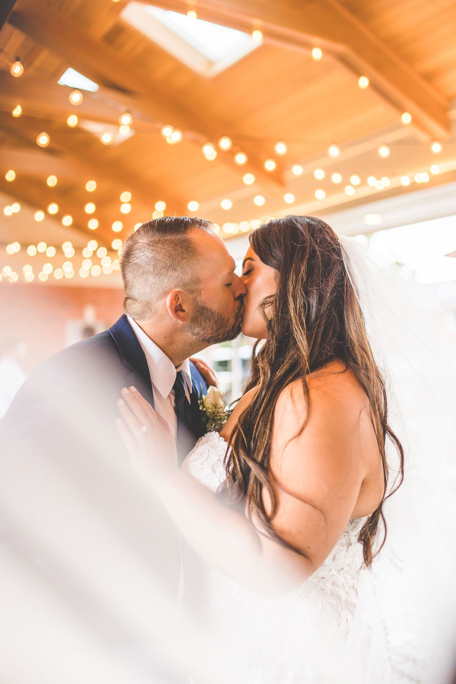 Dreamy wedding portrait with warm lighting and bokeh effects as couple shares tender moment.