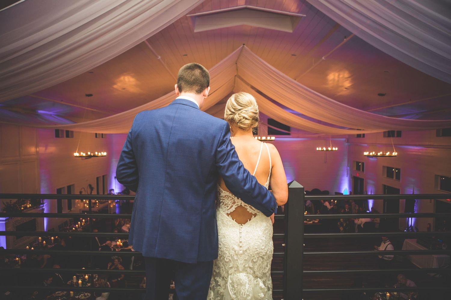 Couple sharing an intimate moment on the dance floor under soft purple lighting.