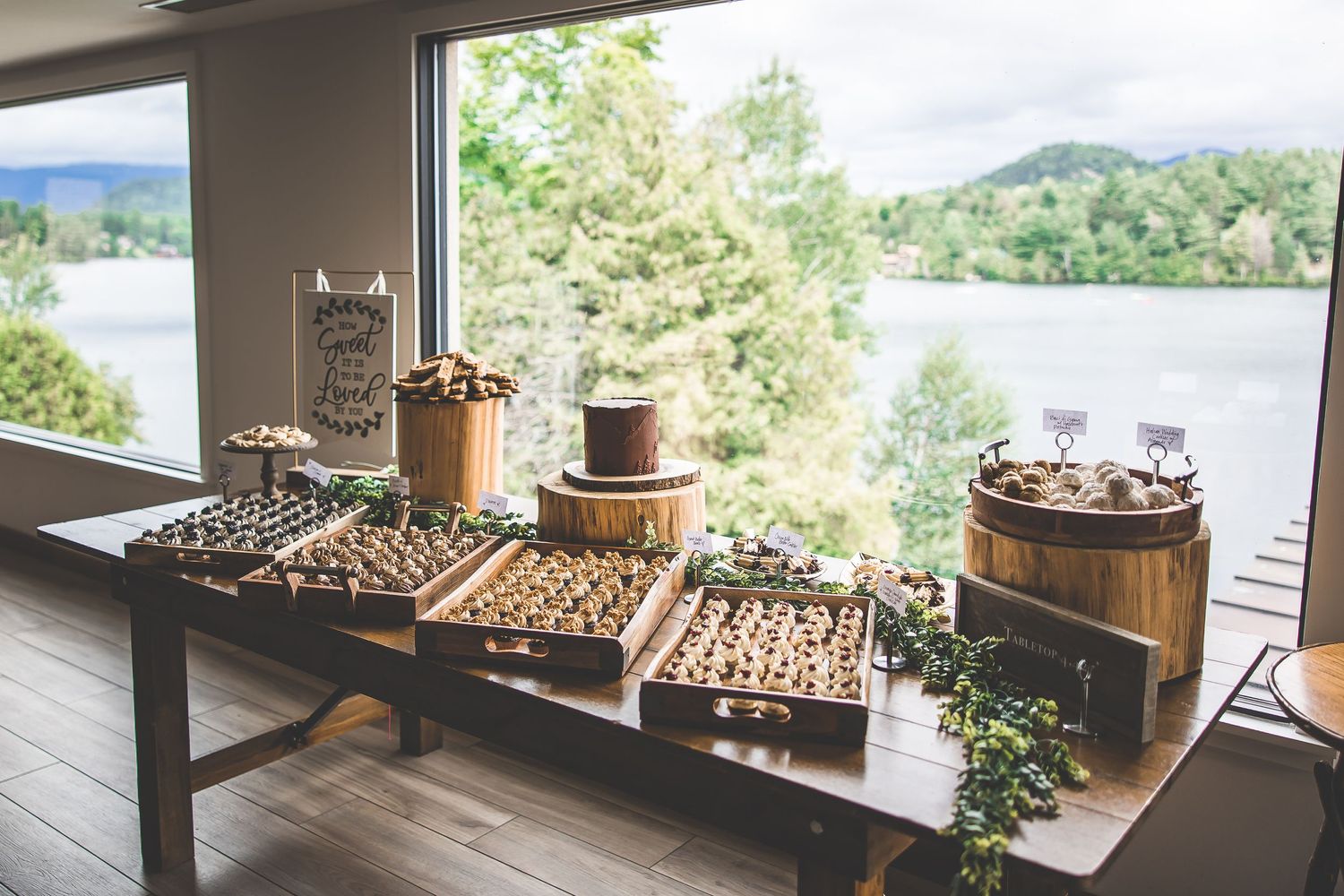 Panoramic mountain view through large windows with rustic wedding decor in foreground.