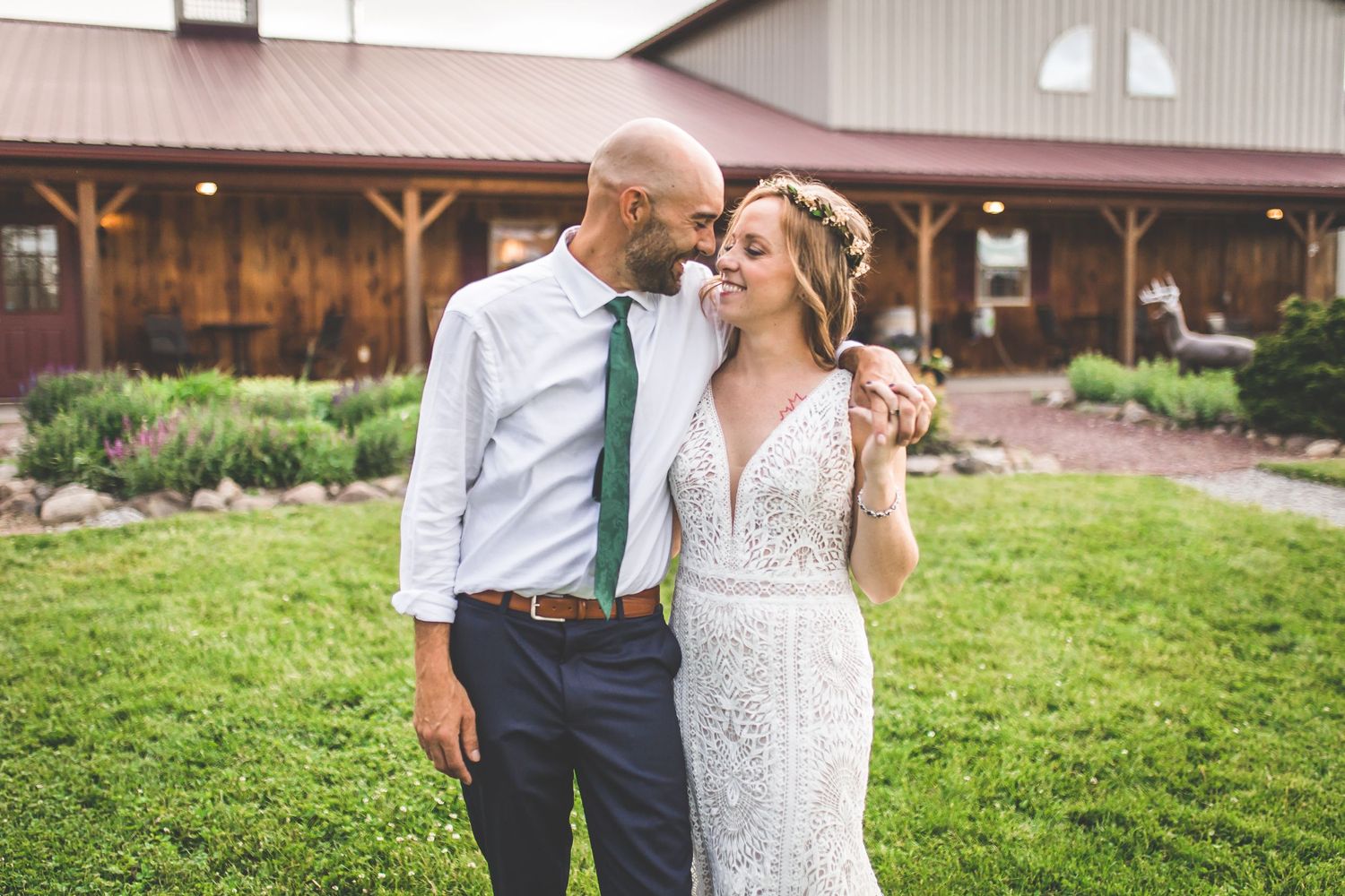 Couple shares intimate moments outside a rustic barn wedding venue.
