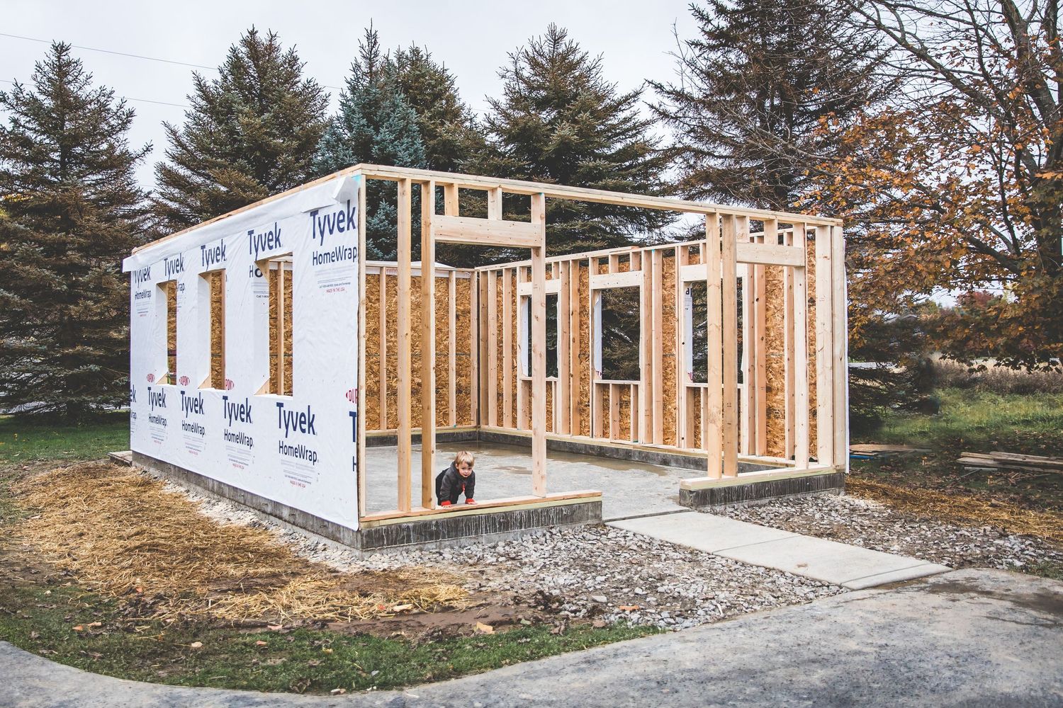 Wood framed home construction progress showing sequential stages from foundation to wall framing and sheathing installation.