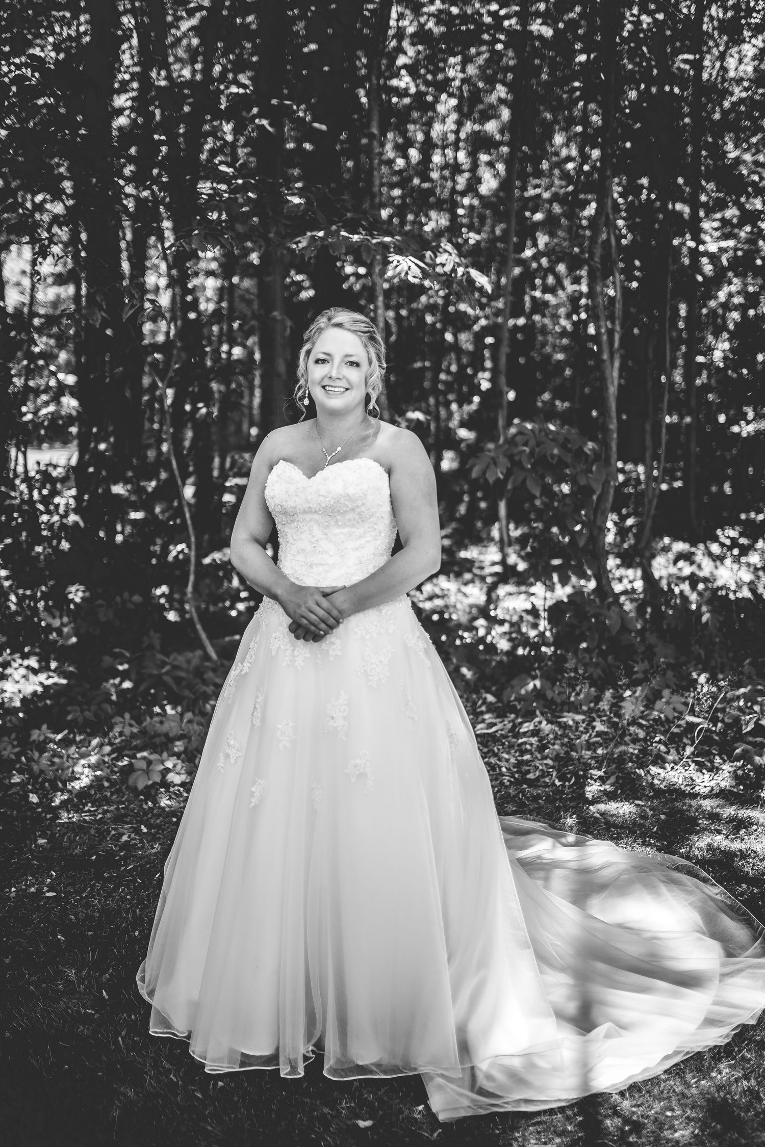 Elegant wedding portrait in forest setting with natural lighting.